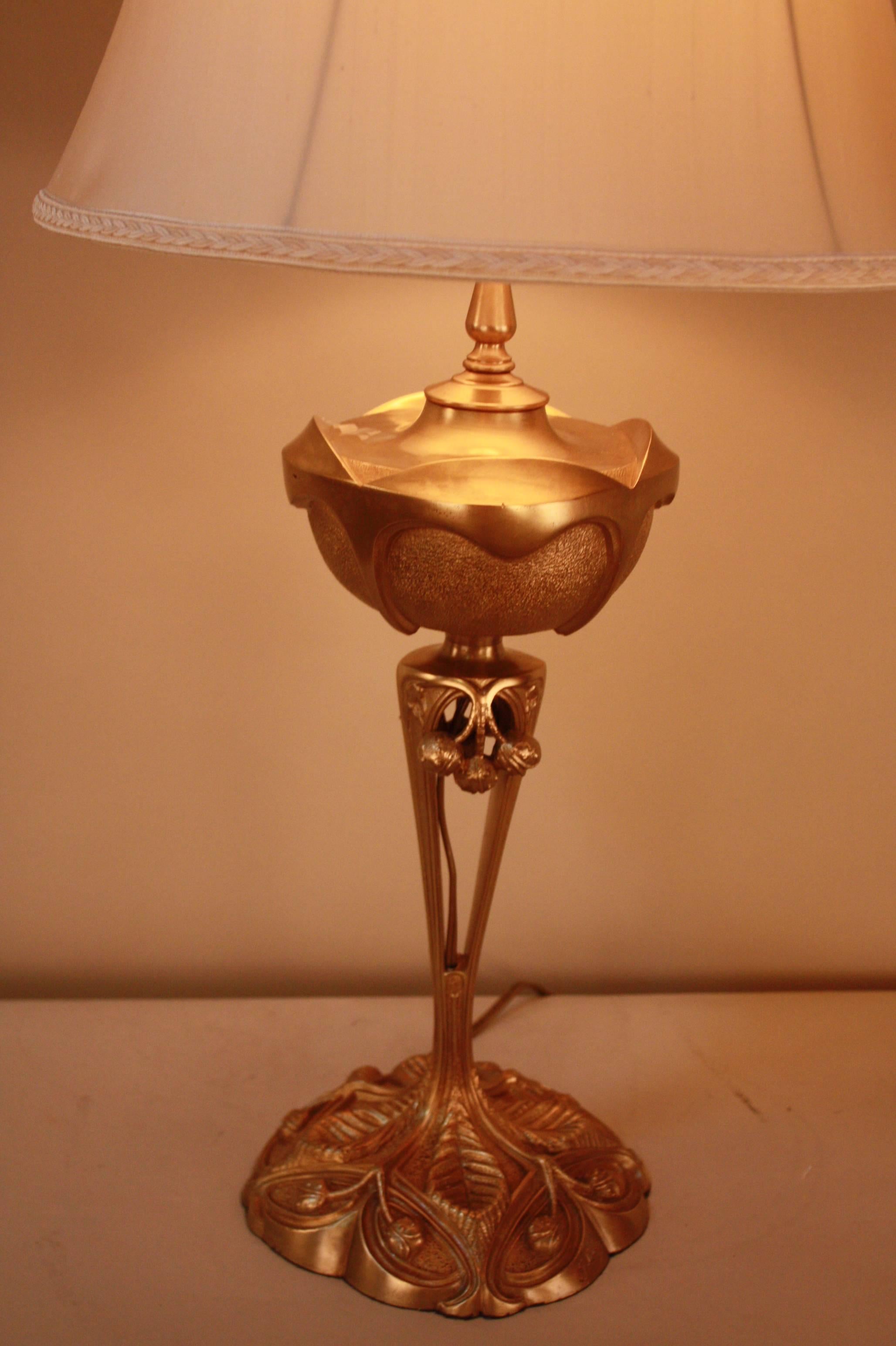 A French Art Nouveau bronze table lamp, that has been transitioned from kerosene to electric. Featuring a flora and leaf base, and G. Leleu's signature (see image 6). 