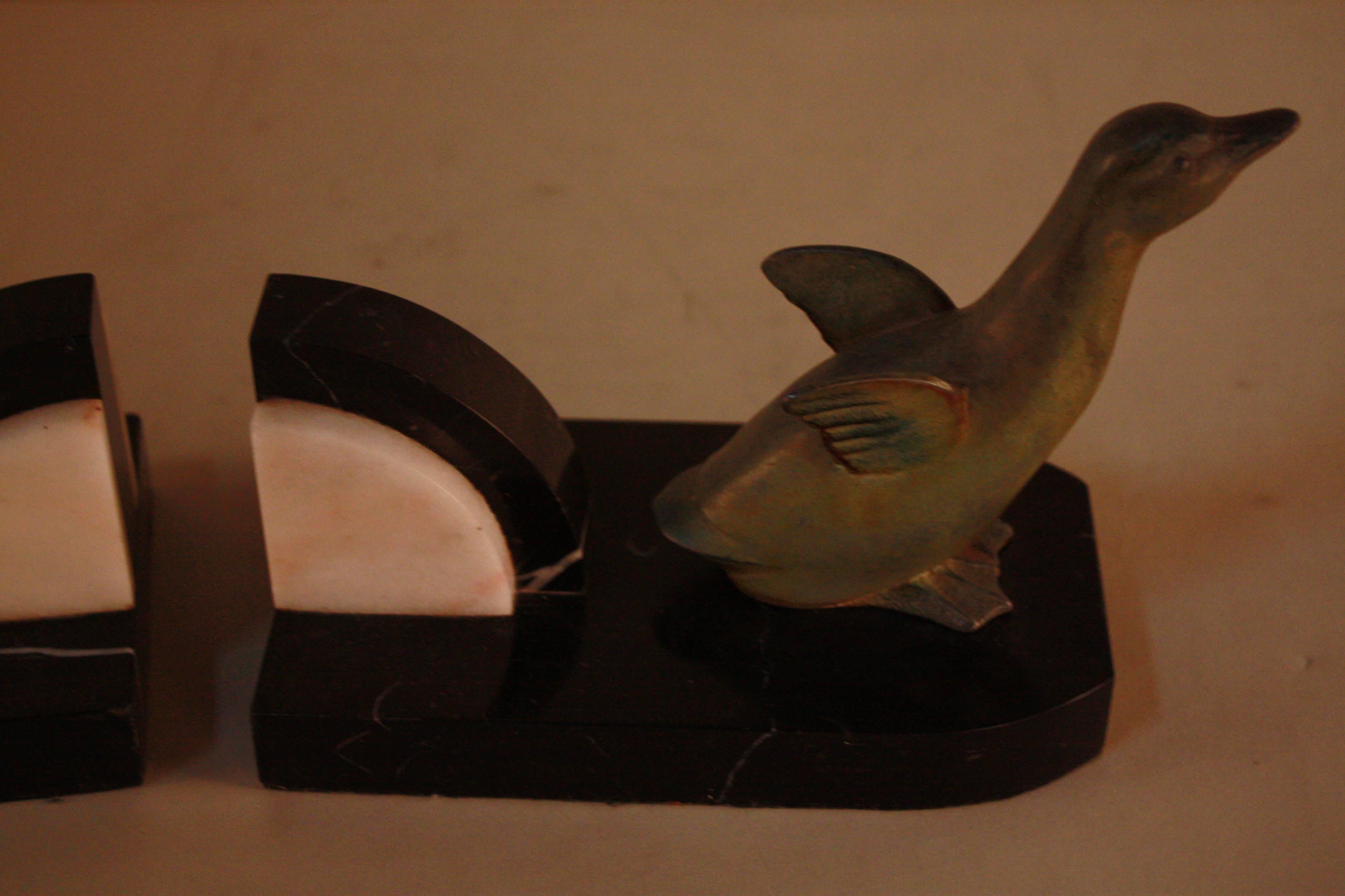 A pair of Art Deco bookends depicting two ducks. Figures made of painted zinc spelter with marble detail (see image two).