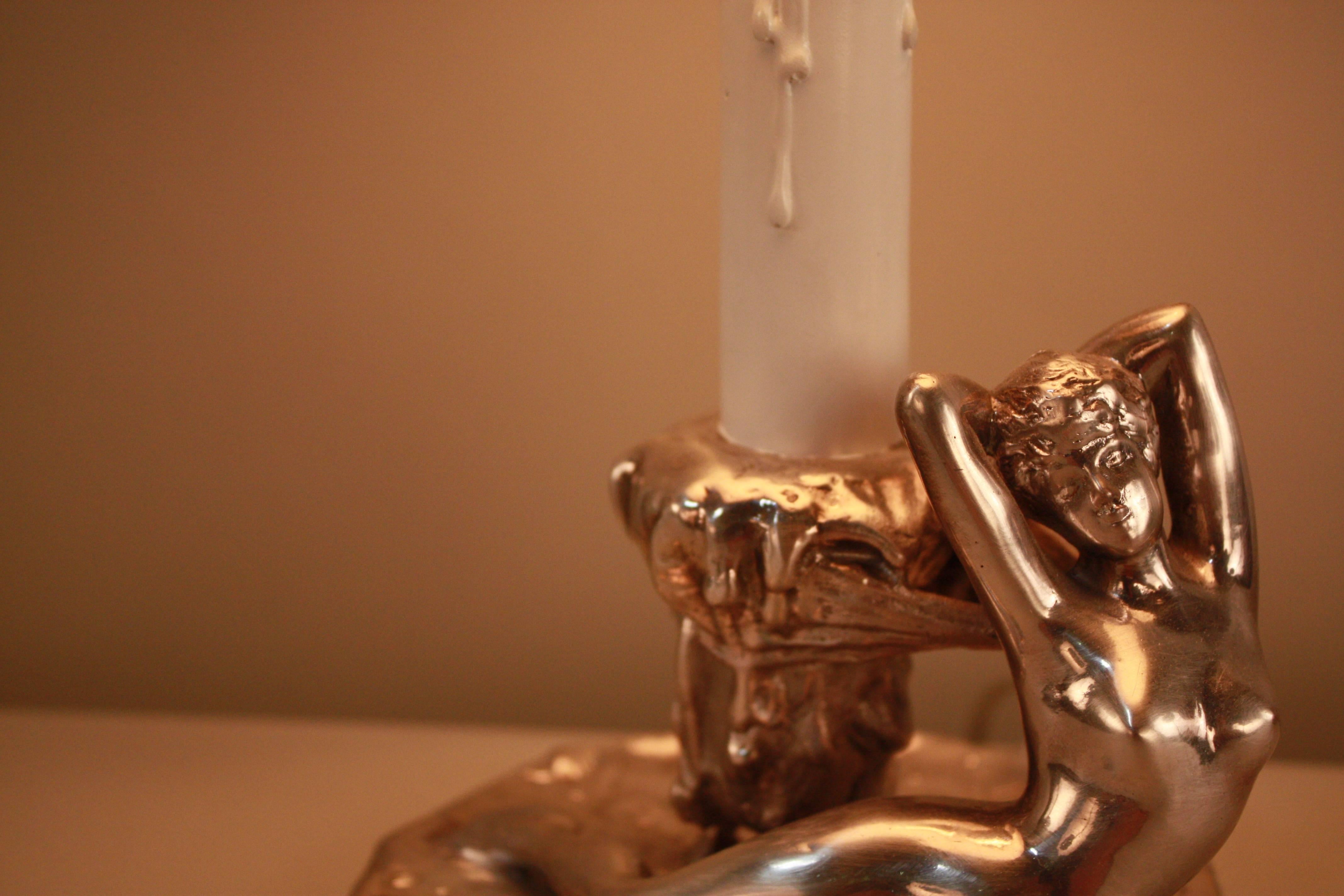 A silver Art Nouveau candle stick that has been electrified as a table lamp. Features a sculpture by Jules Jouant, depicting a nude woman. This piece dates to the early 1900's. 

Jouant made his debut at the Salon of 1883, who is best known as a