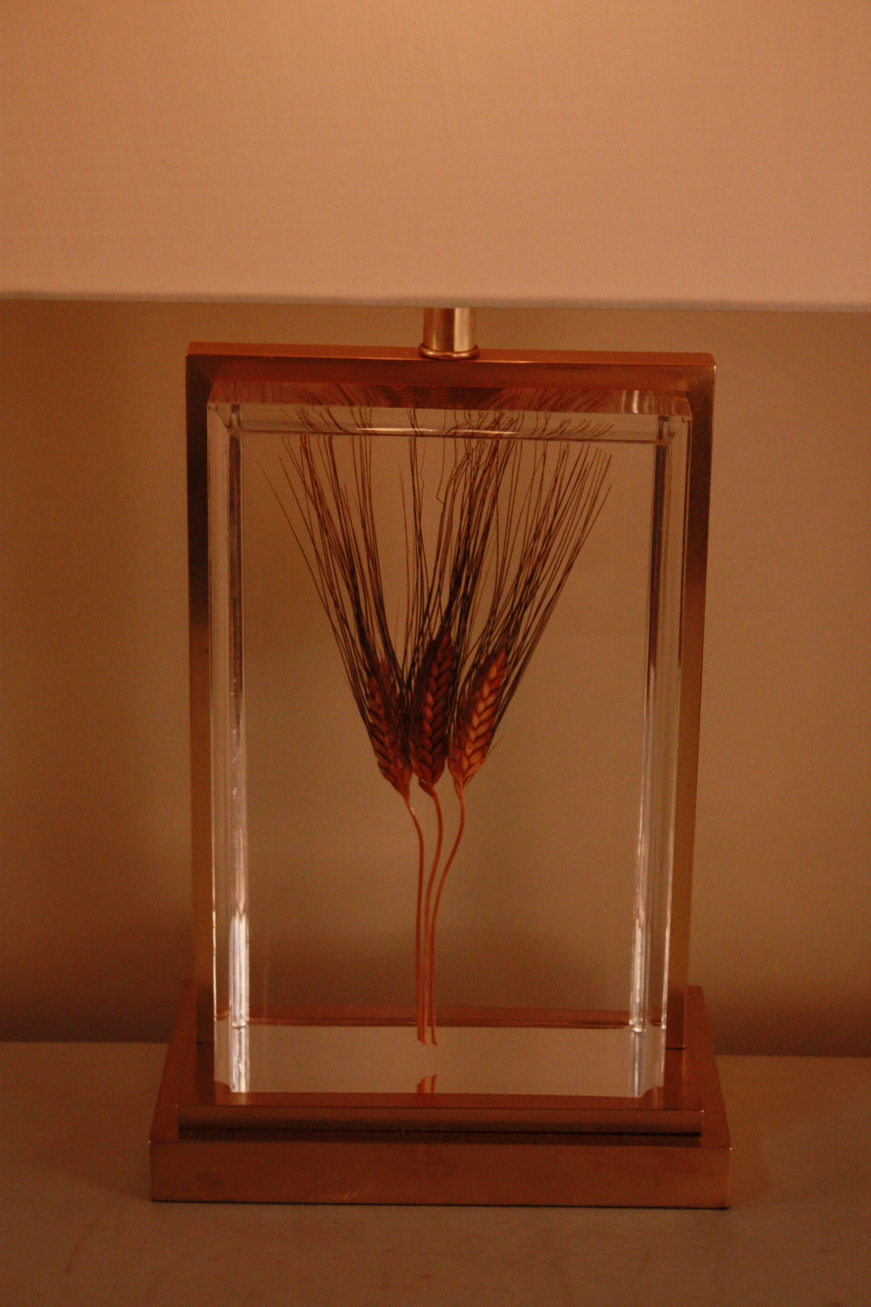 A stunning block of lucite (also known as acrylic glass) with wheat suspended in it. Bronze detailing and a silk lampshade completes this unique piece. 