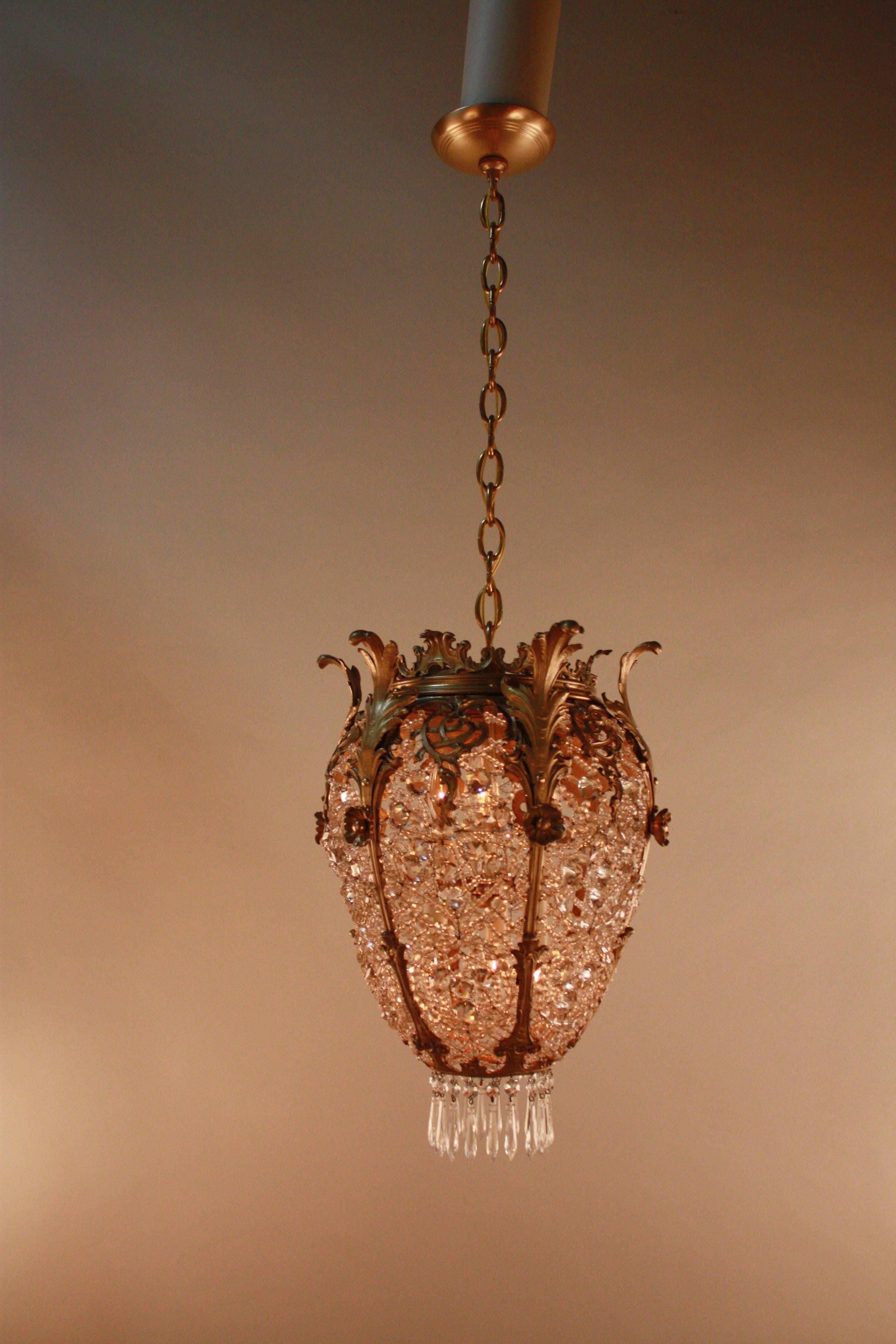 This is a jewel chandelier. Made in France during 1930s all hand decorated clear crystal with bronze framing.
Minimum height fully installed 25