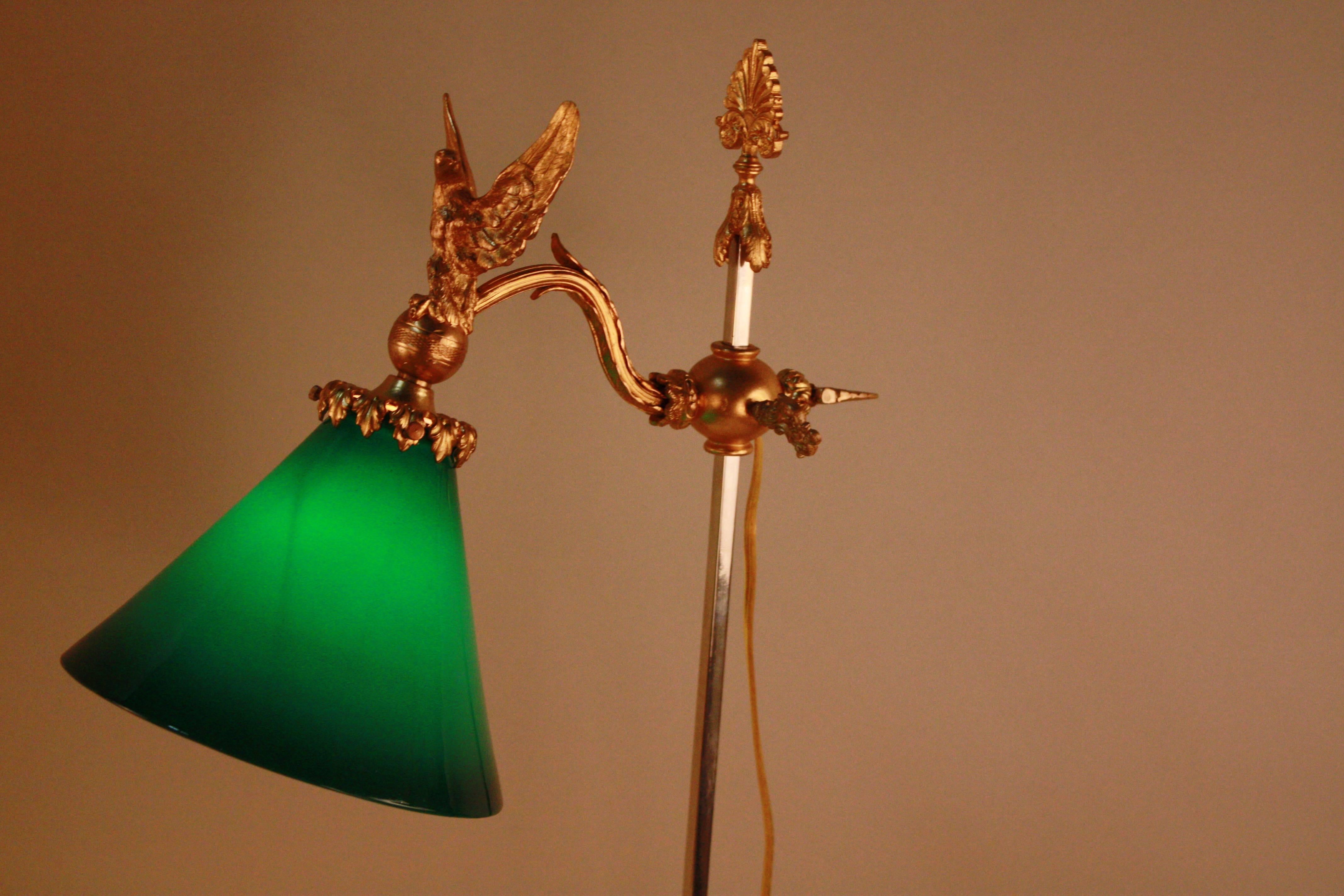 A wonderful golden bronze adjustable lamp, depicting a soaring eagle holding a case glass green shade. Provides the perfect pop of color for a study or lounge. 
