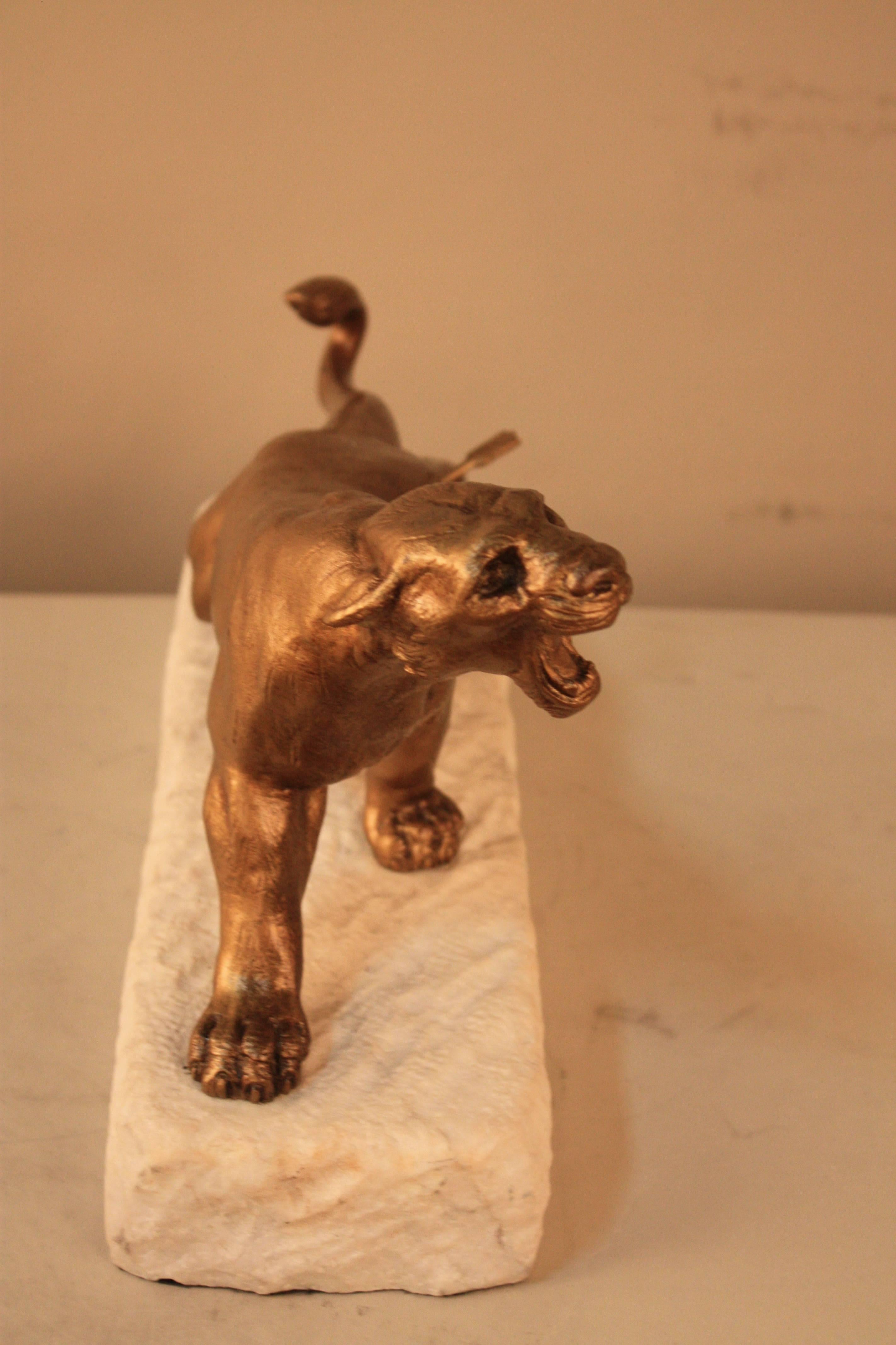 Sitting atop chiseled marble, this early 20th century piece depicts a tiger being hunted via bow and arrow. Detail of arrow can be seen in image three. 