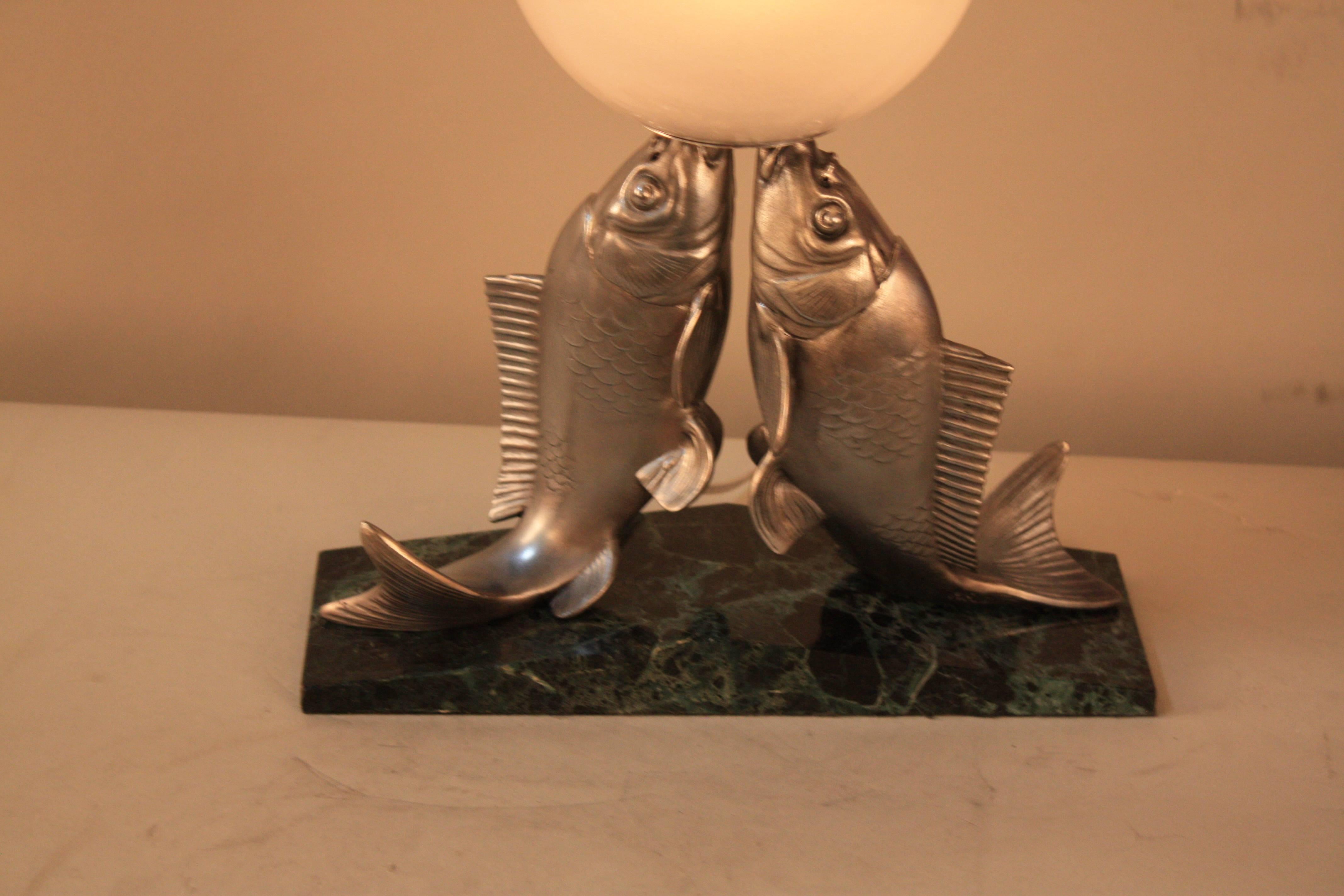 Adorable Art Deco lamp with fish playing with ball.
Frost glass ball, spelter and black marble with green veins.