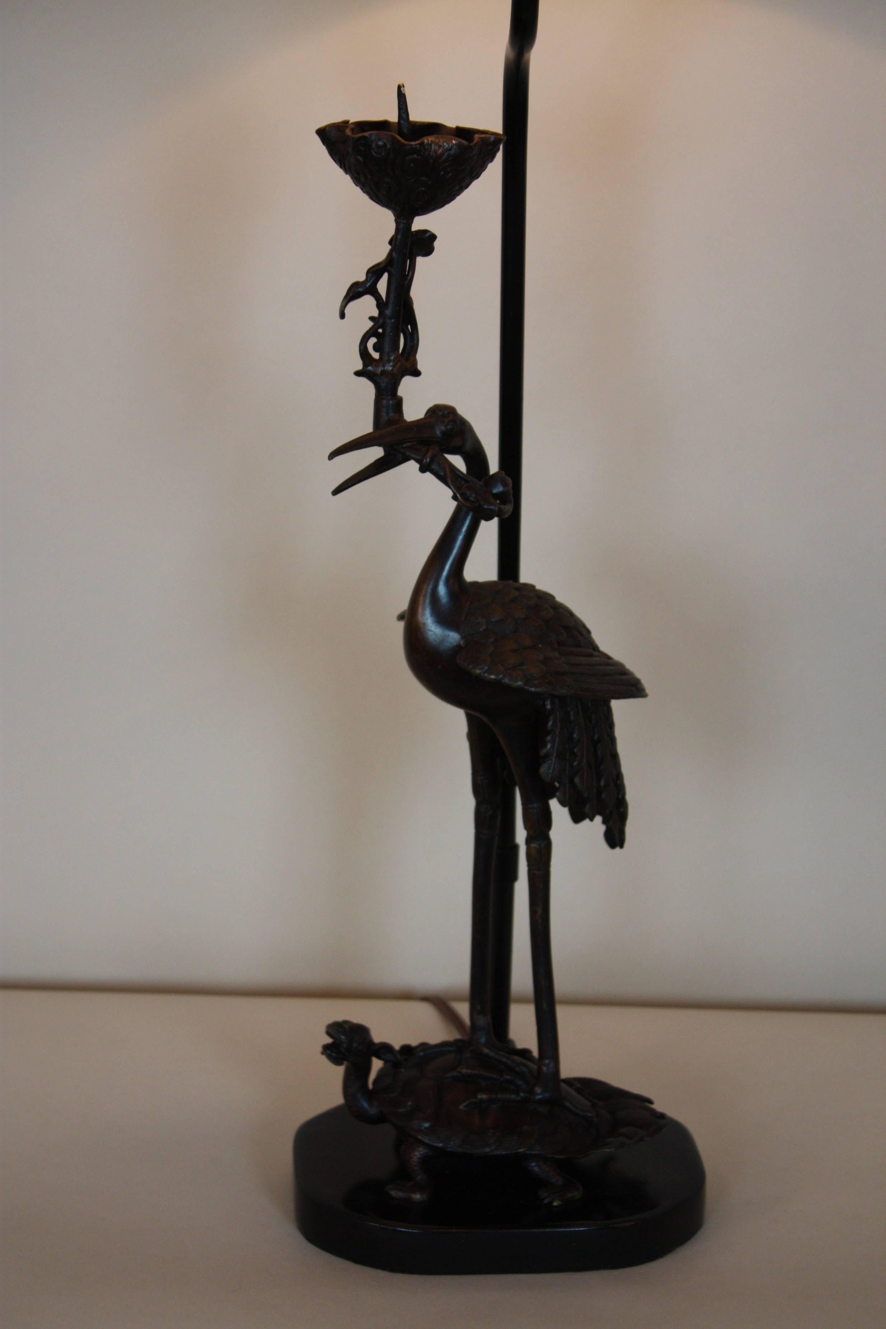 Elegant 19th century Chinese bronze candlestick. The crane on the back of the tortoise (symbol of longevity) that has been customized as a table lamp.
This lamp is fitted with hardback linen shade.