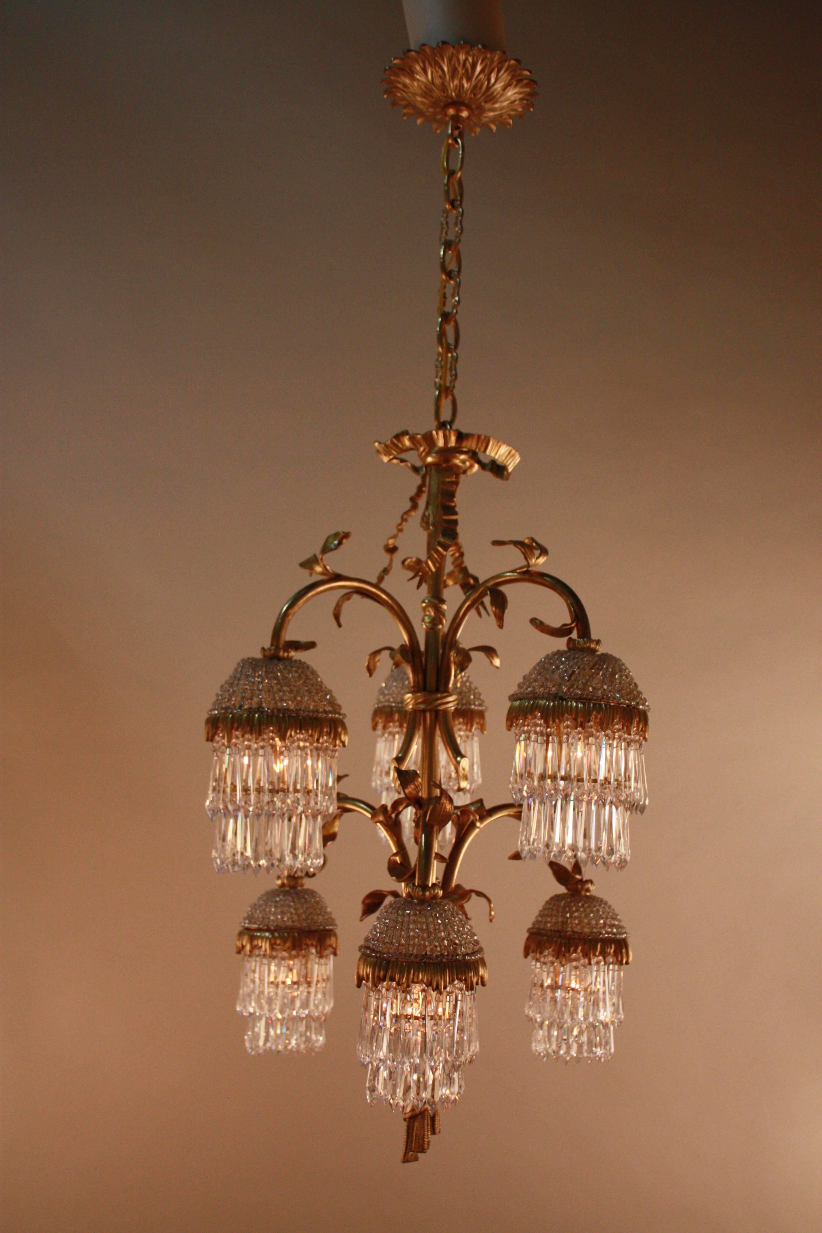 Inspired by the nature, a centre column with six flora design bronze branches, each branch has beaded crystal dome with two treas crystal drops.
Very rare and well design chandelier.