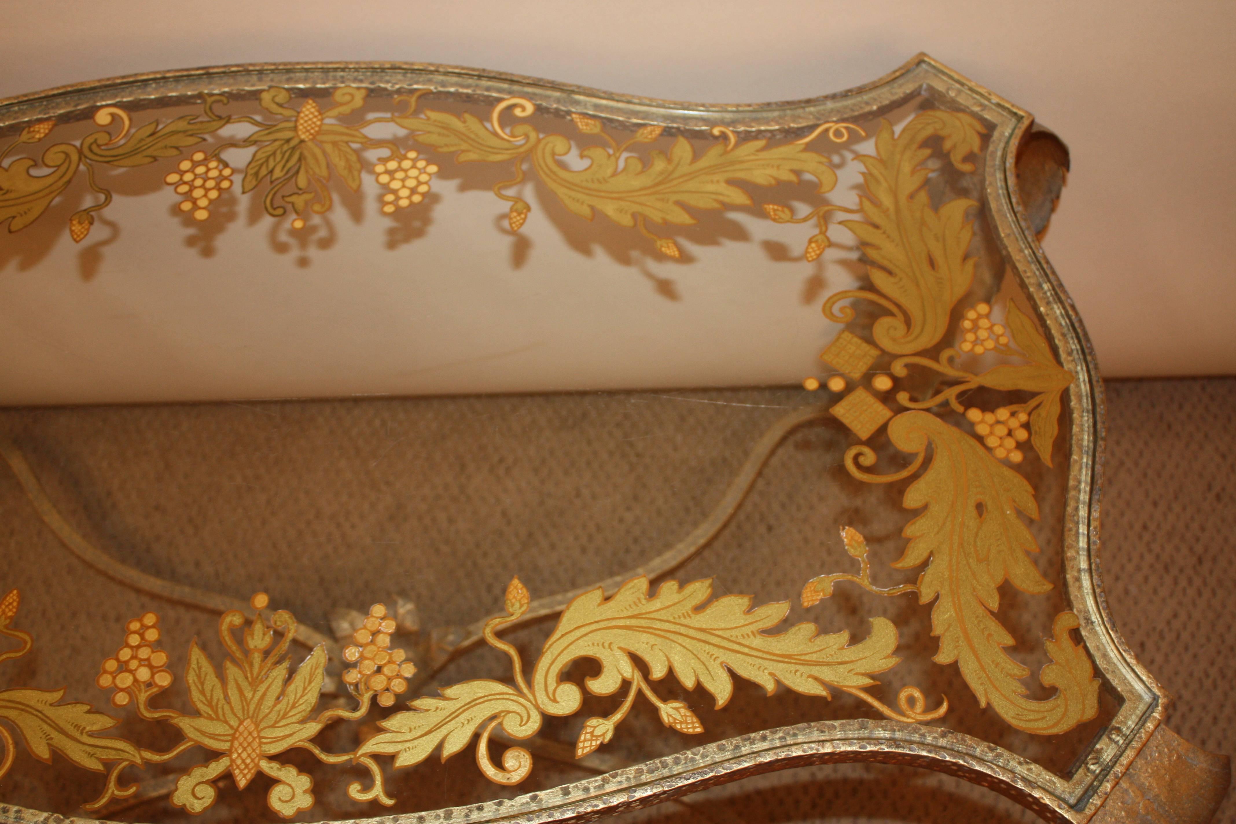 Wrought iron coffee table was finished in gold leaf with reverse paint glass top.