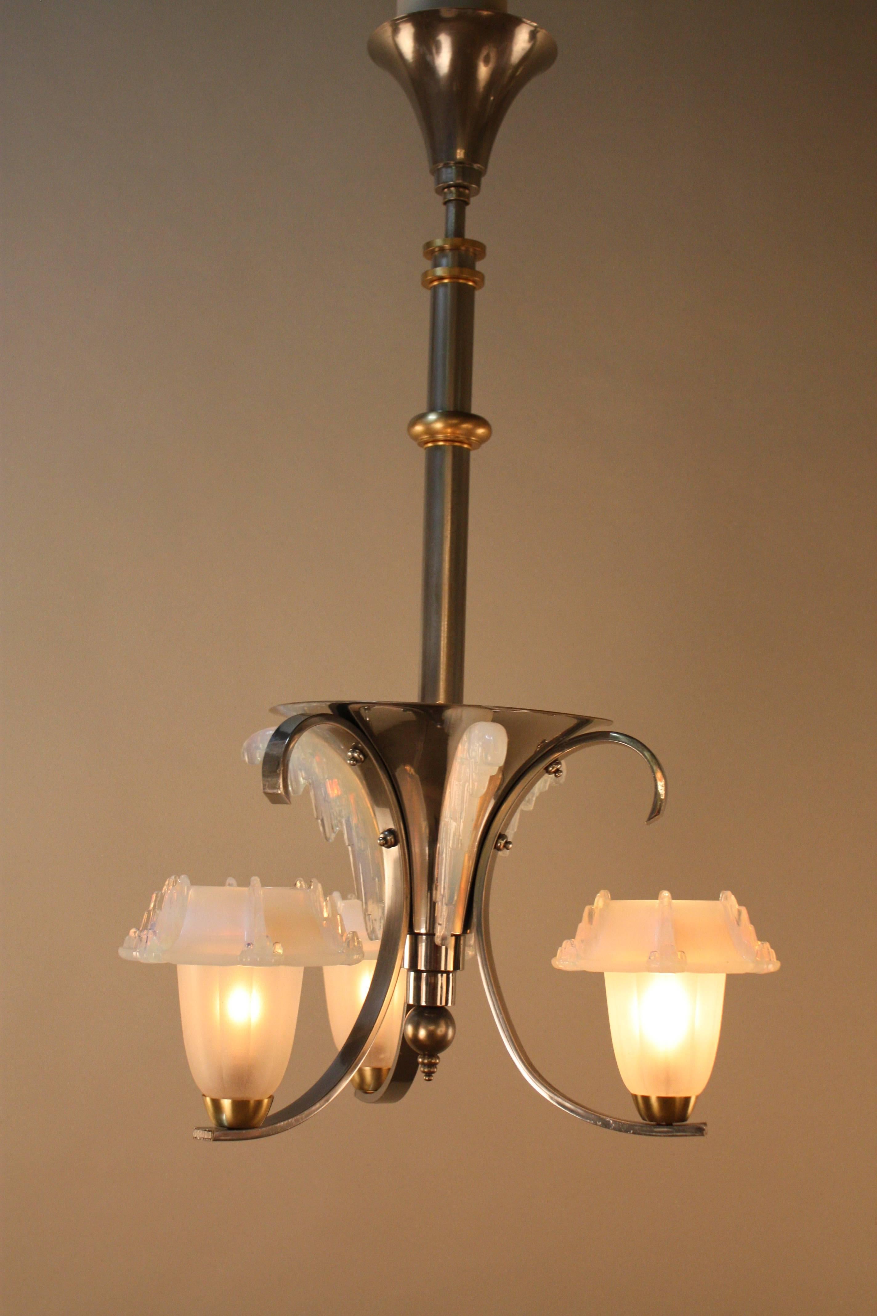 A simply stunning French Art Deco chandelier with opalescent glass shade. This chandelier has original chrome on bronze finish with some bronze accent pieces.
Total of five lights 60 watt each.