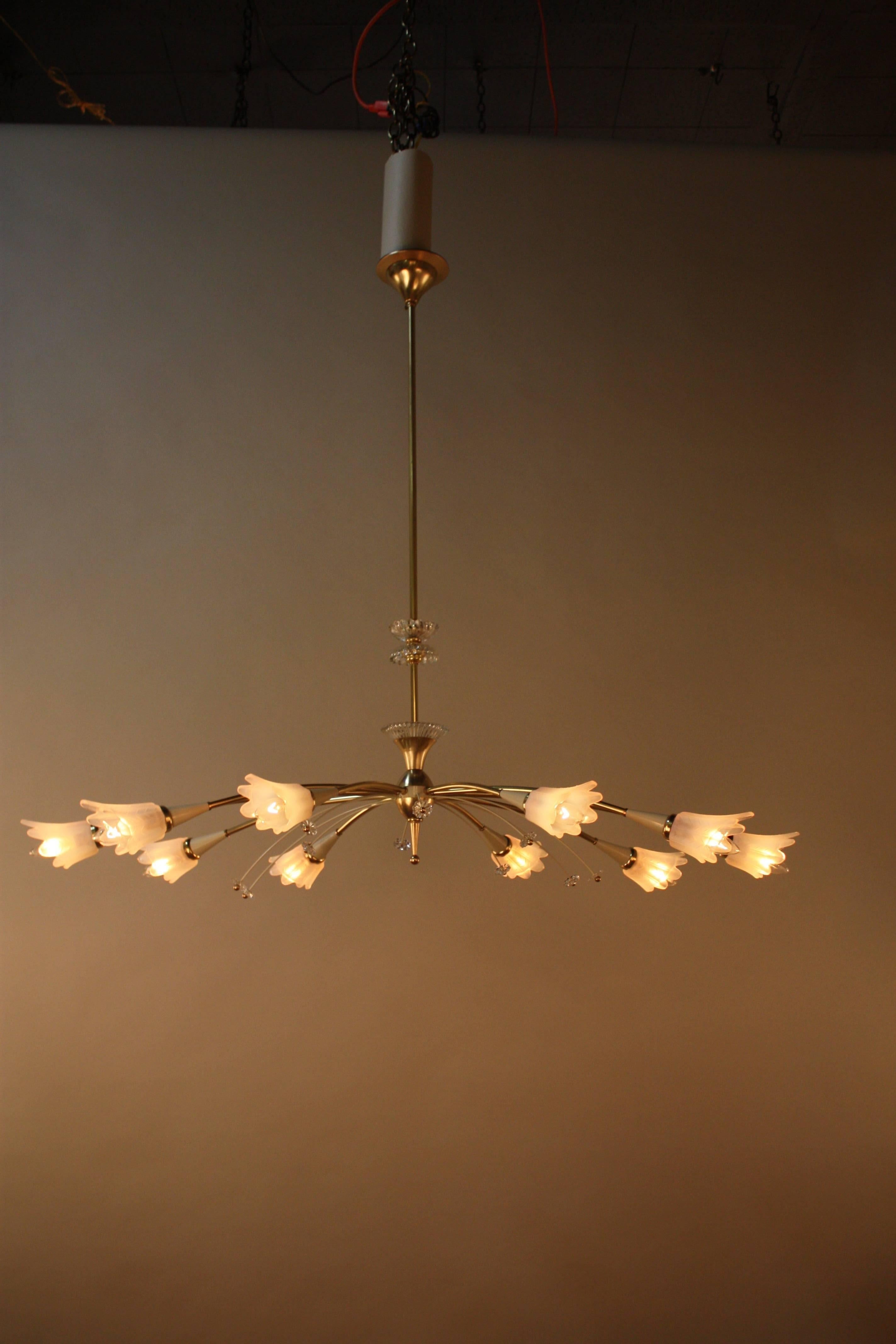 This French chandelier was made in the 1950s of bronze and cream color lacquer and Opaline glass. The lovely glass detail surrounding the bulb follows the star burst theme. Featuring ten lights total, this piece will illuminate any room.