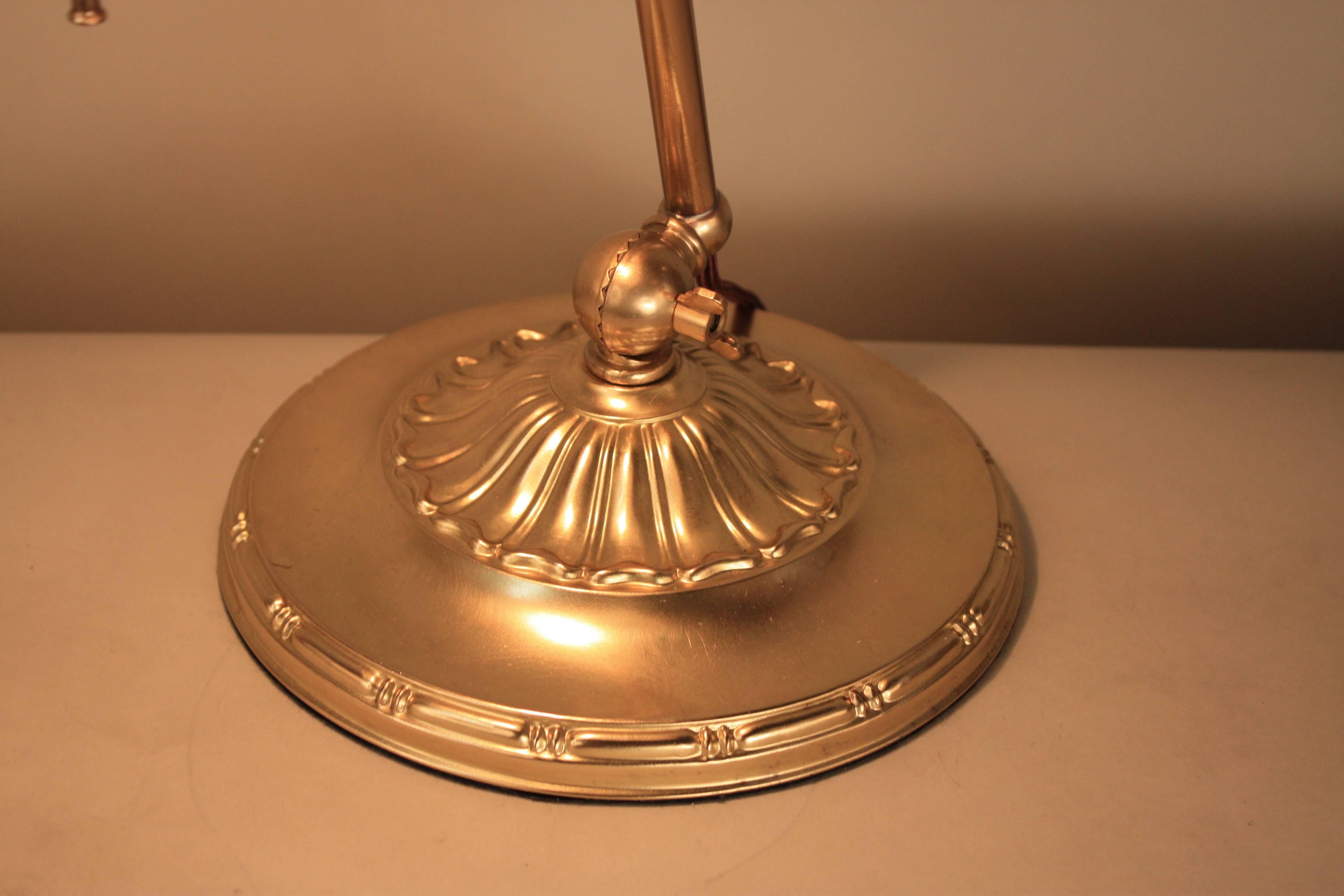 A Classic piece of Americana, this beautiful Emeralite desk lamp was originally made in 1916. This superb lamp features a beautiful brass base, a fabric covered cord. A versatile piece, the lamp is adjustable from the top and the base.