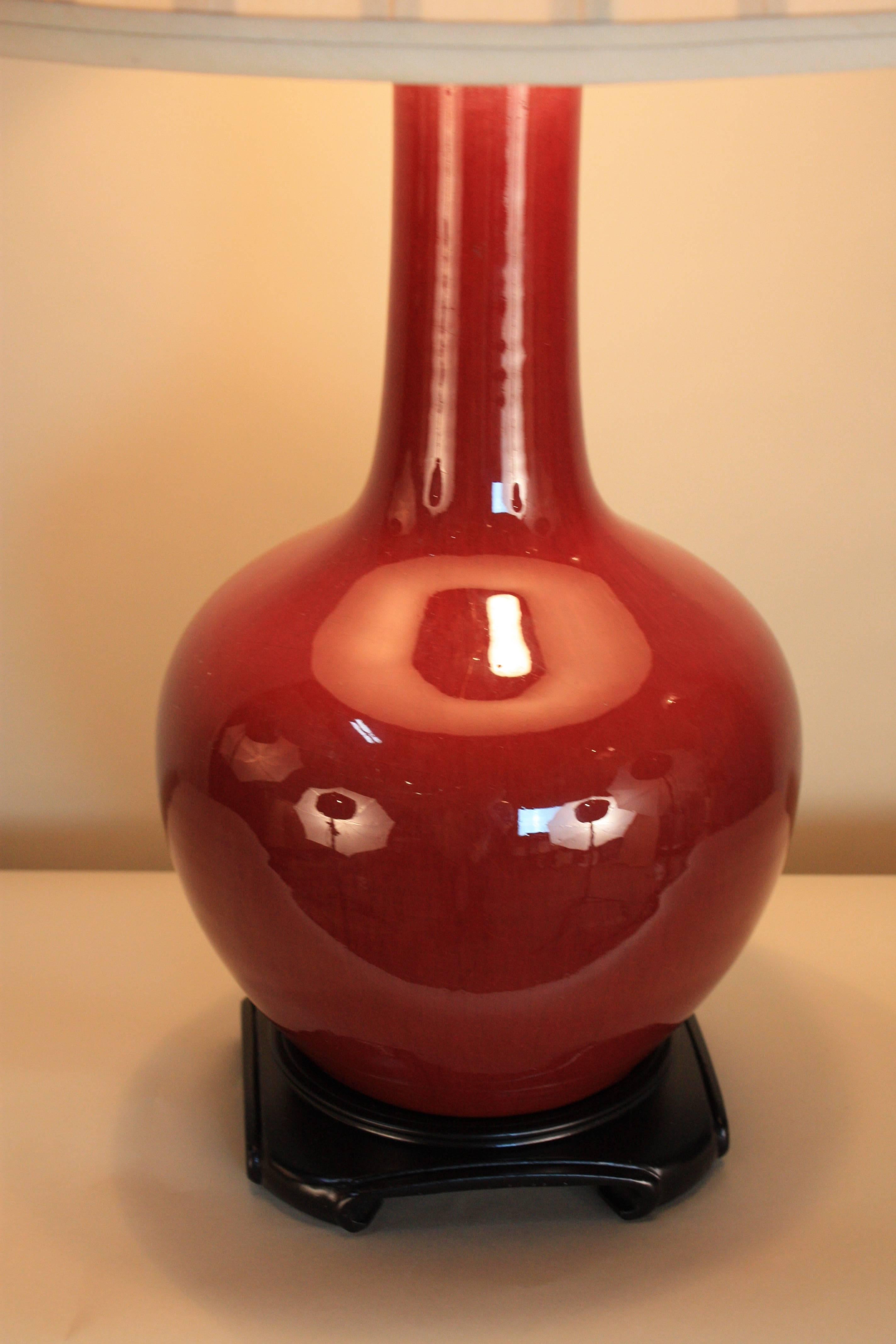 Chinese Sang de Boeuf oxblood porcelain vases monochrome flambe glaze red that has been customized as a table lamp with double socket and box pleated silk lampshade.
    