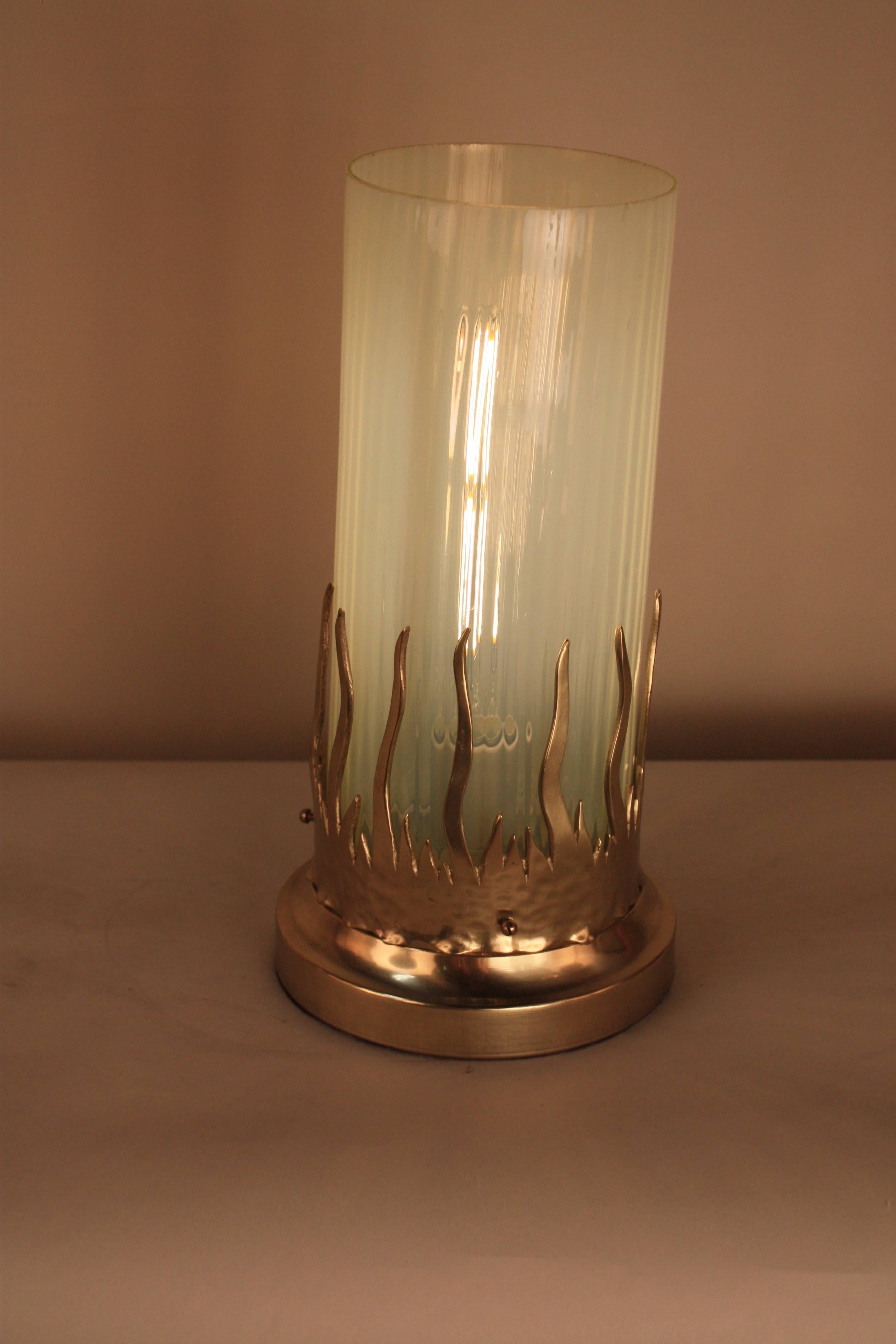 Flame design bronze table lamp with handblown honey green color opalescent glass shade.