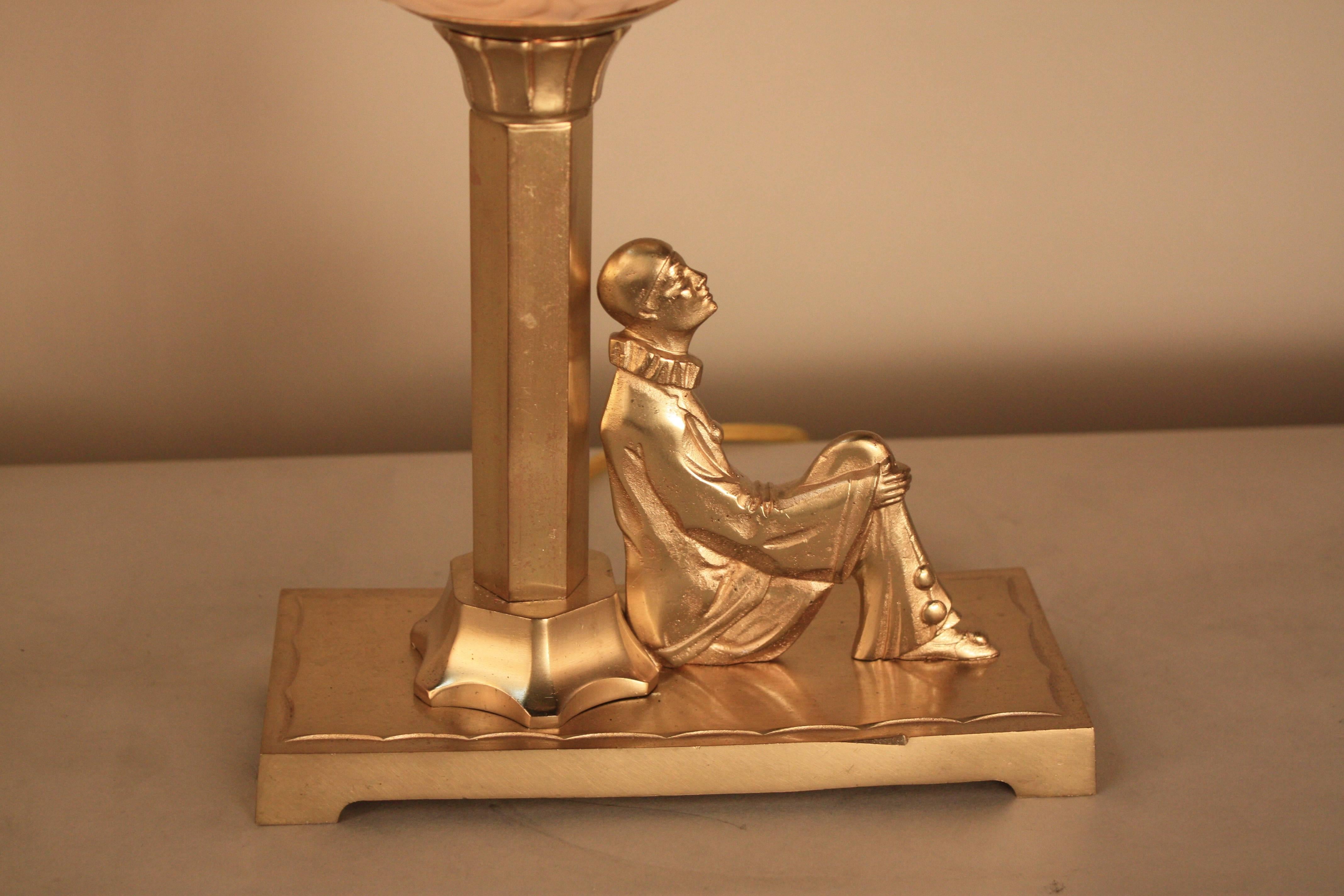 Harlequin sitting under the light, beautiful bronze table lamp with textured glass shade.