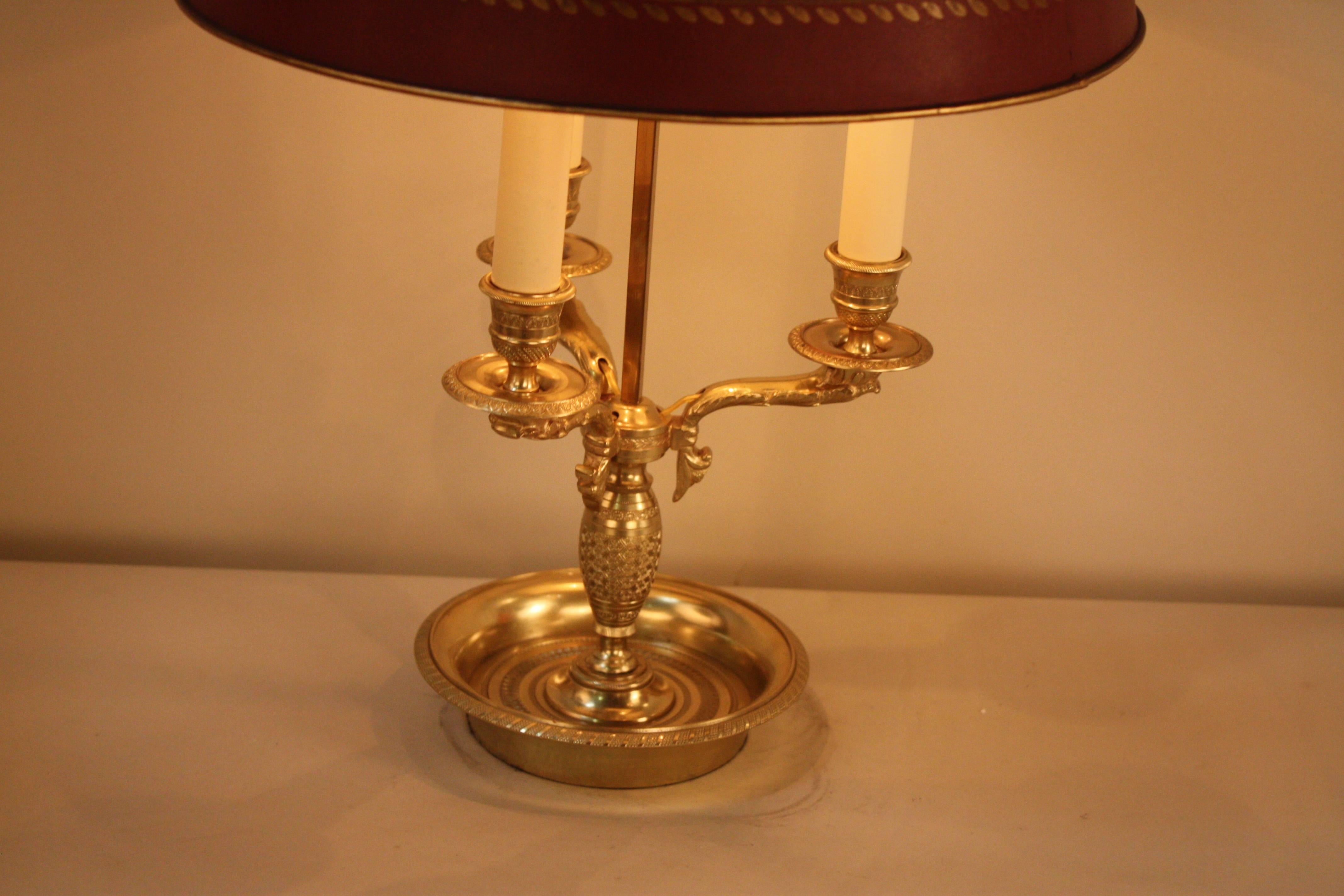 A fabulous three-light French bronze Empire style bouillotte table lamp with adjustable burgundy metal shade.