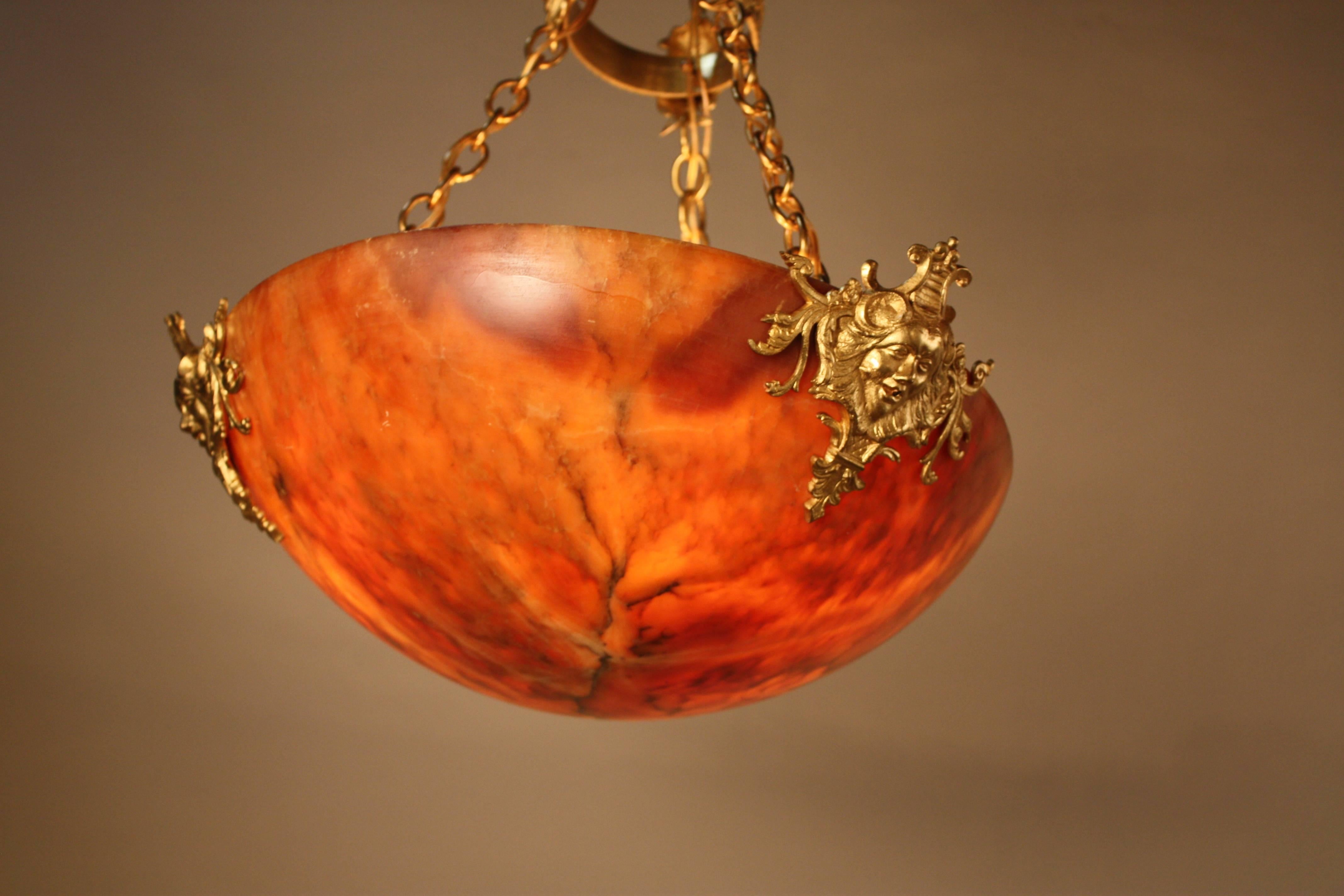 This six-light chandelier is made of beautiful warm colored alabaster, with a fantastic bronze pendant. The pendant itself features great bronze detail as well. The pendant comes in long chain and some chain can be removed for shorter height if