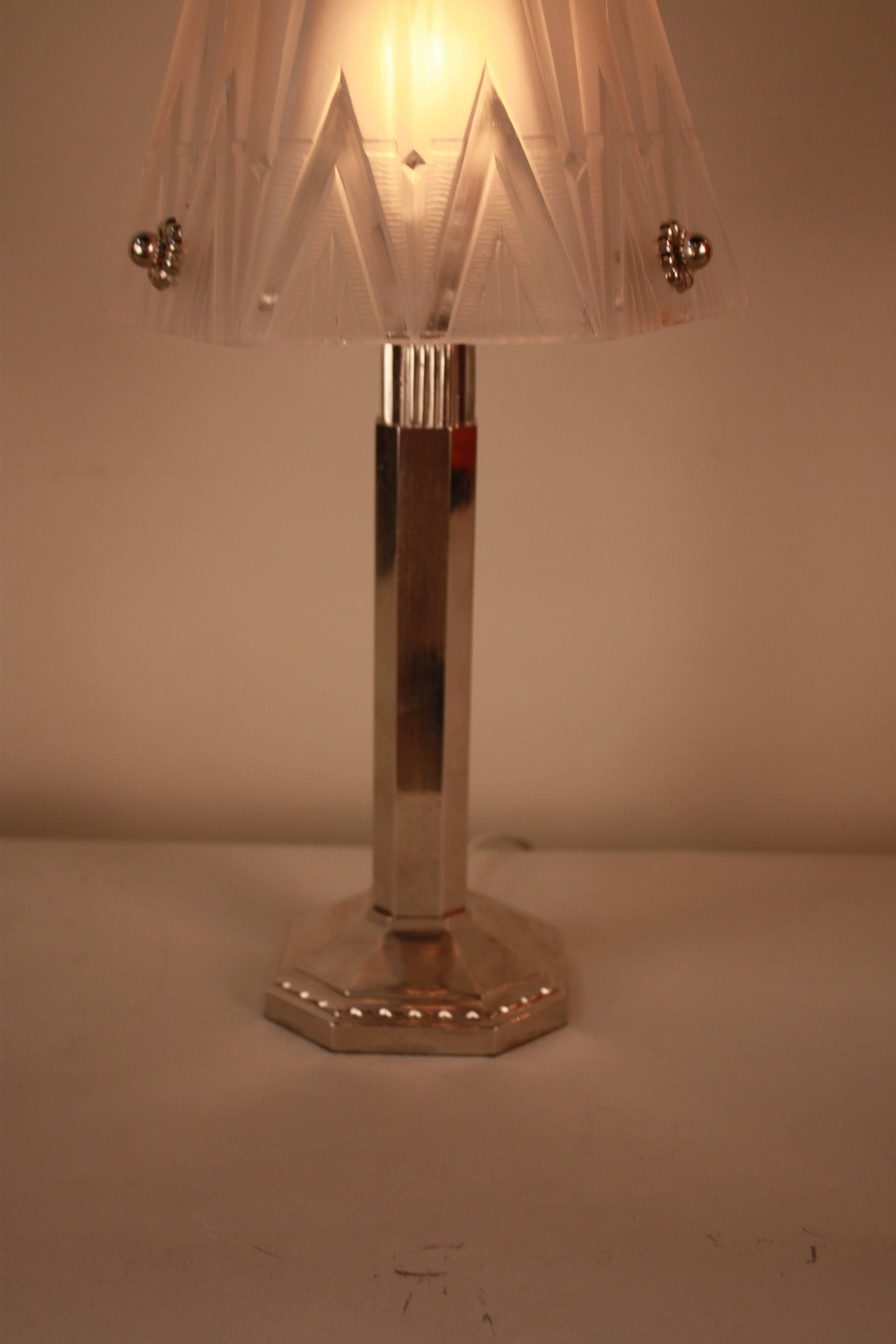 A geometric 1930s French Art Deco table lamp features a square nickel on bronze base with hexagon clear frost shade.
