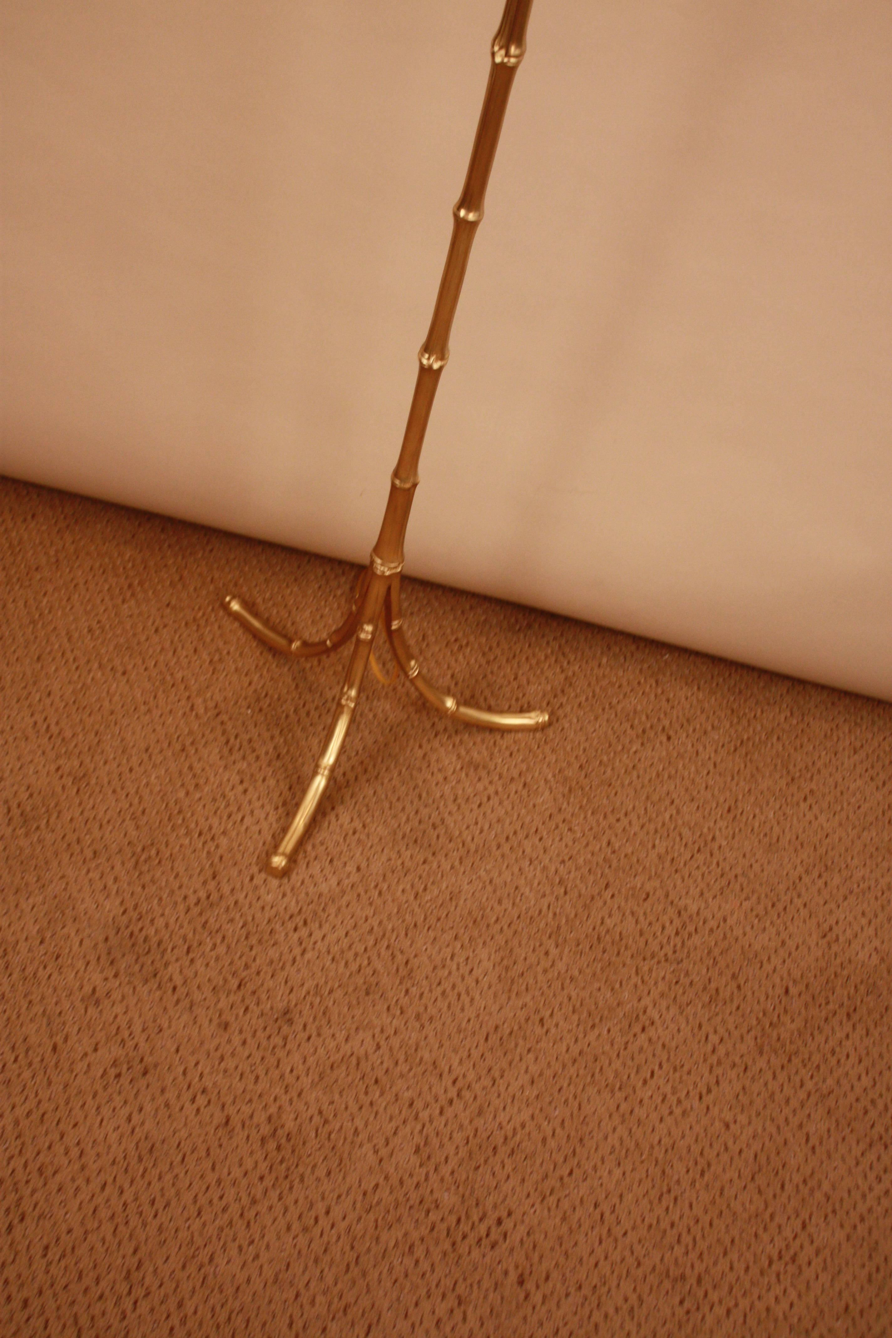 Elegant Maison Bagues faux bamboo bronze tripod floor. This floor lamp has been modified with American sockets.
Three sockets, 100 watts each.
New hardback silk lampshade.