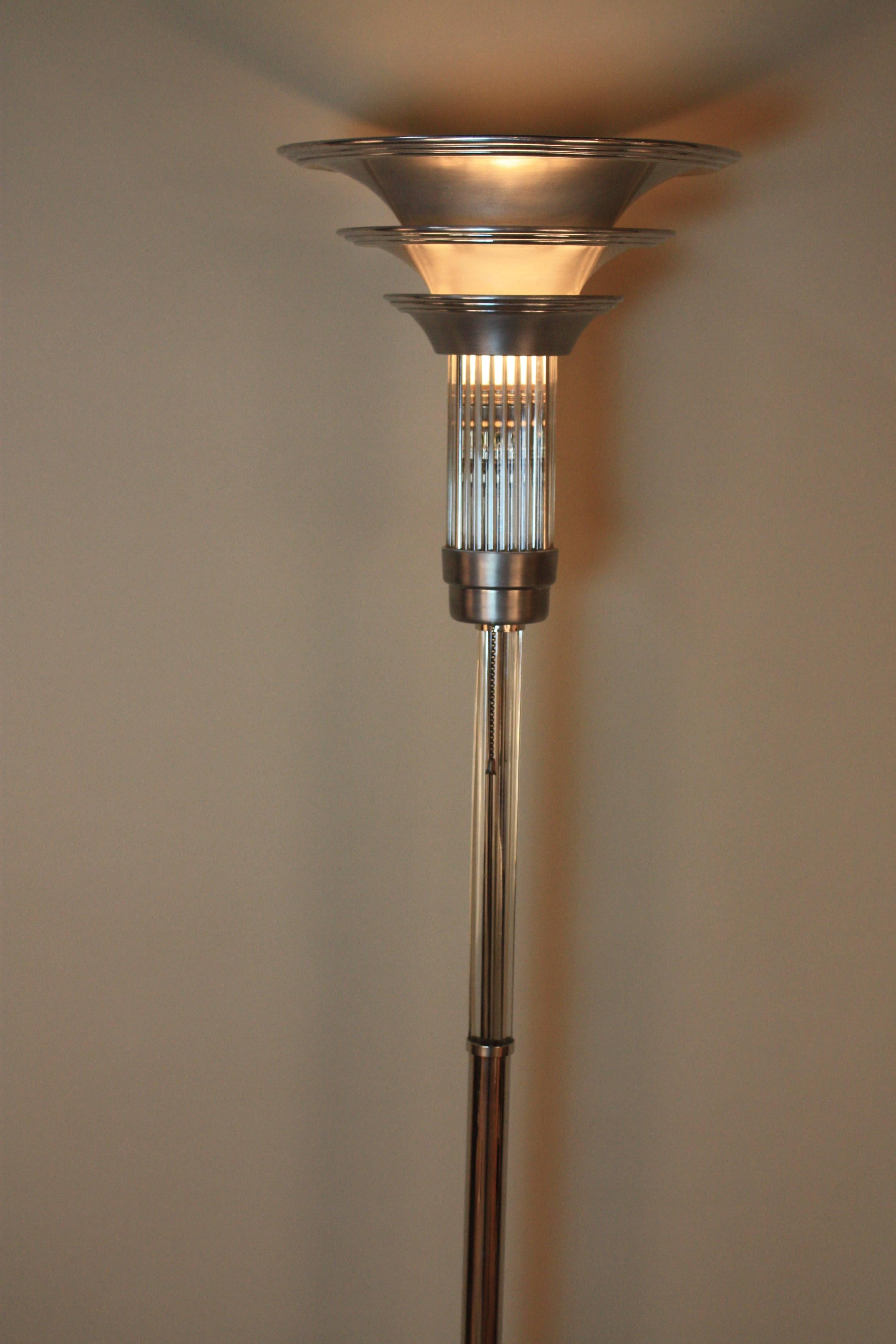 A stunning and rare 1930s American Art Deco torchiere floor lamp. A round nick base, nickel and glass center column with aluminium cup that holding glass rods with a triple shade polished and brushed aluminium.
