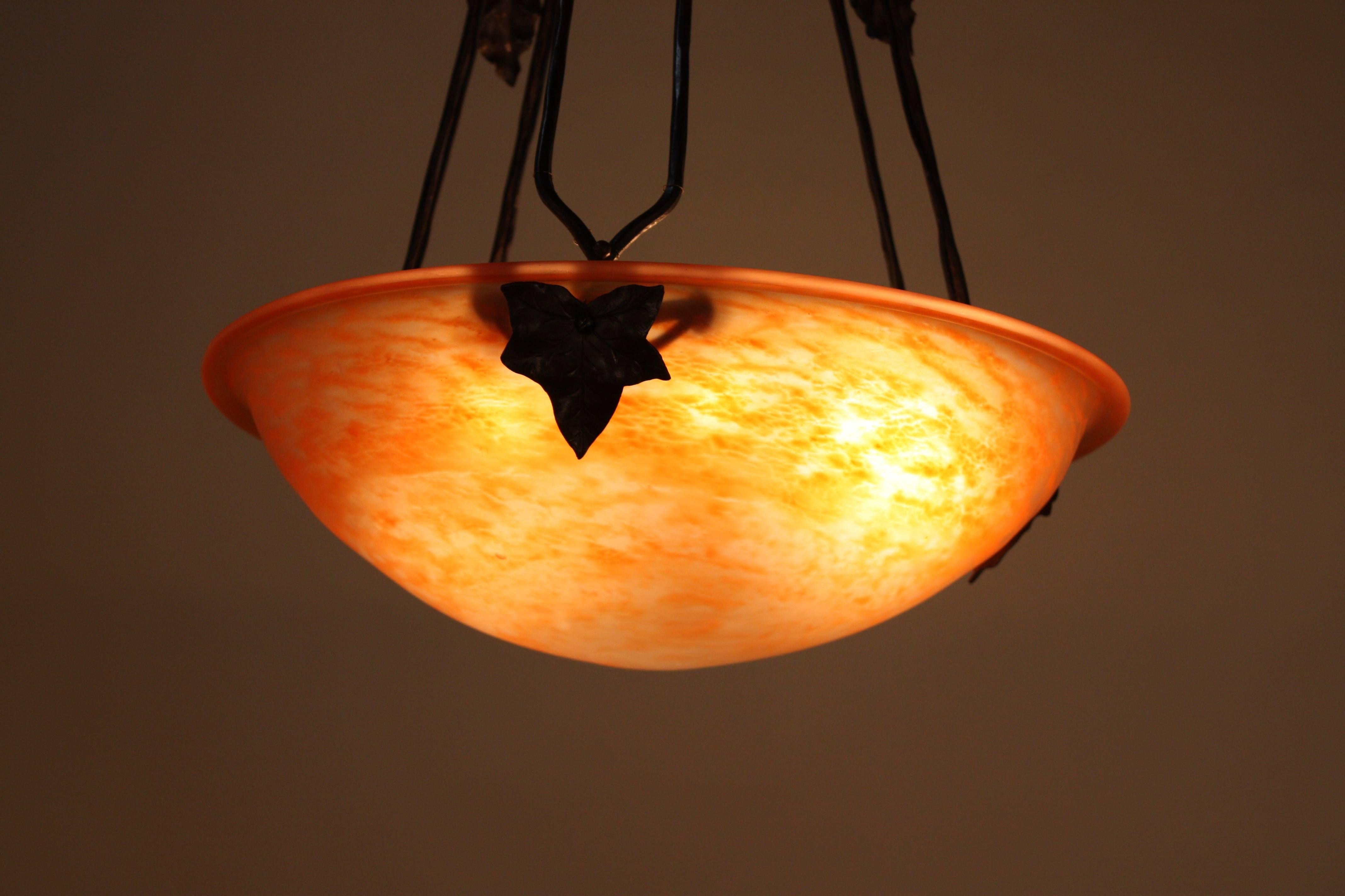 French blown glass in honey orange color suspended from hand forged iron canopy and rods.
Total of six lights, 60 watts max each.
