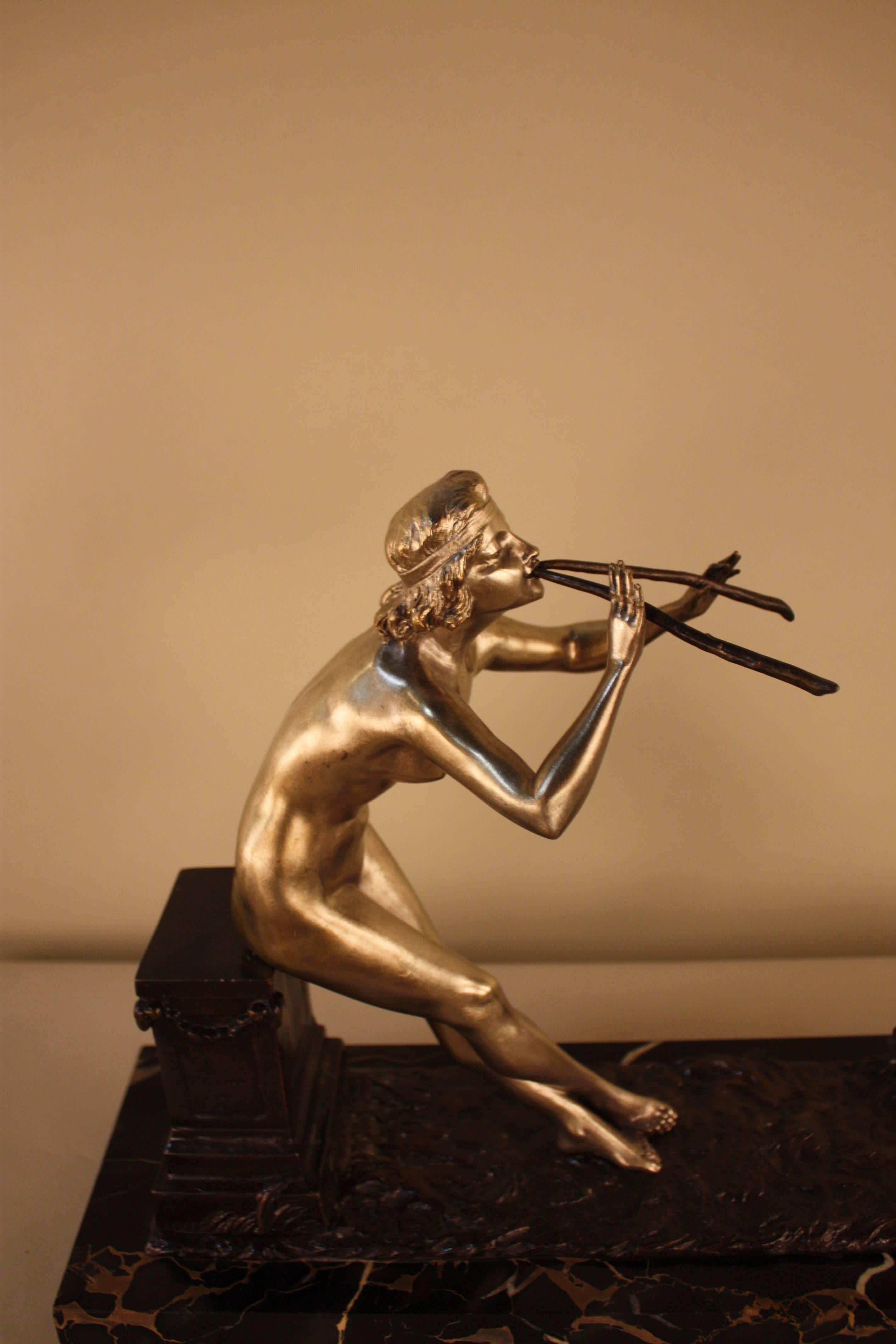 Bronze sculpture featuring a nude woman playing two horns while a small goat dances on two feet. 
Silver on bronze and brown bronze with the marble base.