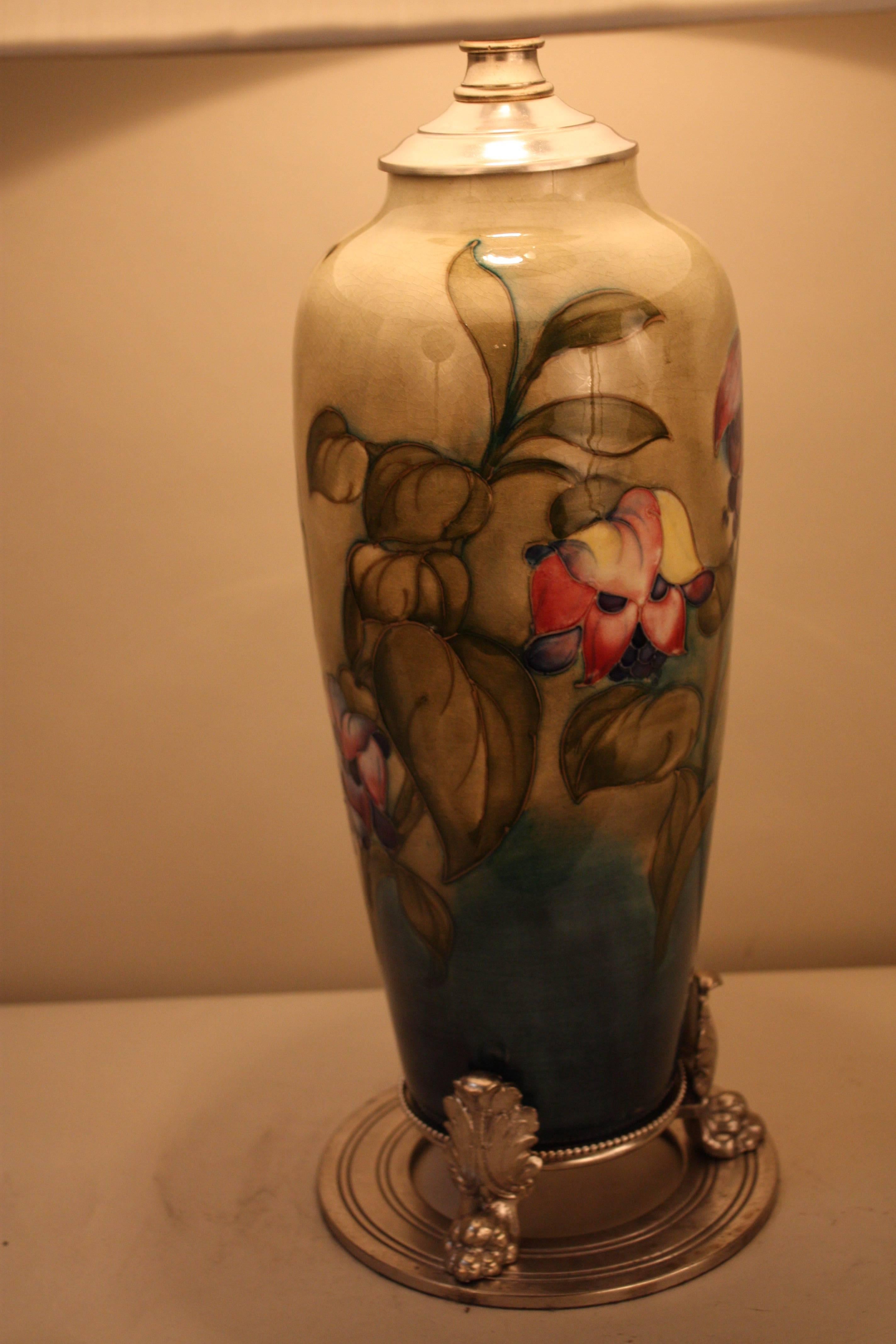 Hand-painted highly glazed decorated with richly colored flora Art Nouveau style vase by Moorcroft that has been made to a beautiful table lamp.
Silver plate base and hardware.