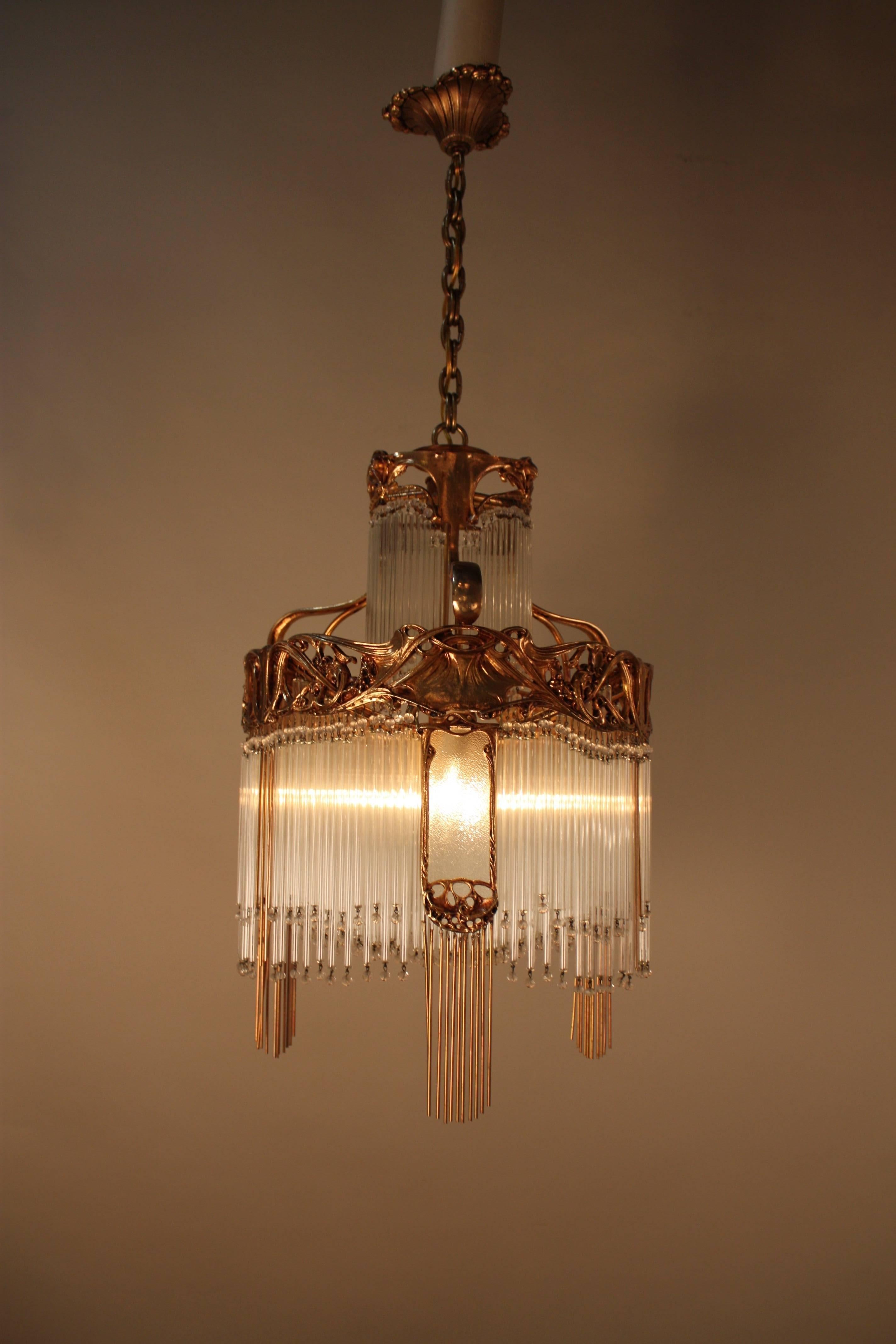 Pair of stunning Art Nouveau chandeliers is made of bronze and blown glass tubing. These beautifully done piece that is a fantastic example of Classic French artistry. This fixture has a total of six lights, 60w each.
Measure: Total height of this