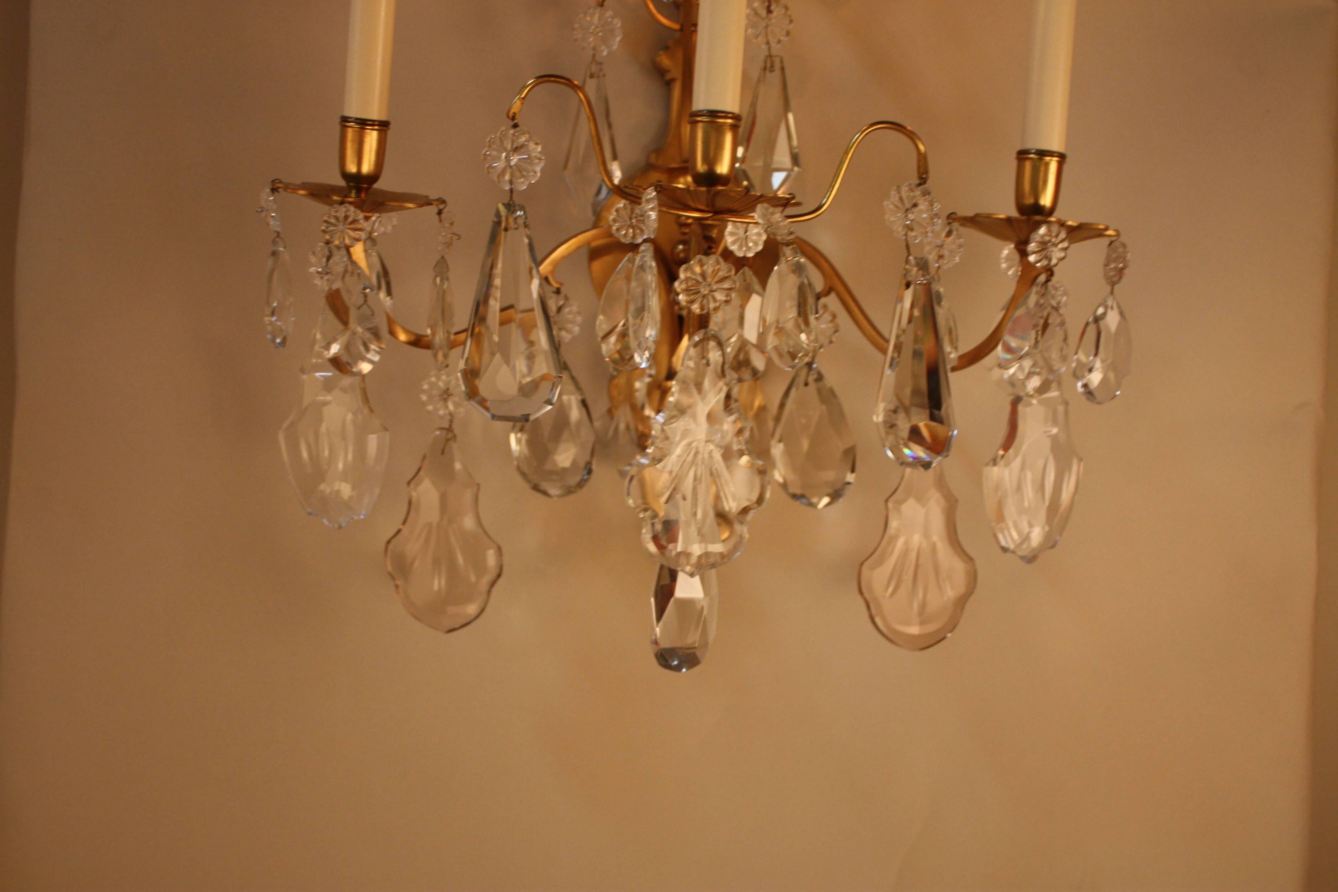 Pair of 1930s three-light bronze and polished crystal wall sconces.
Measurement: 11.5