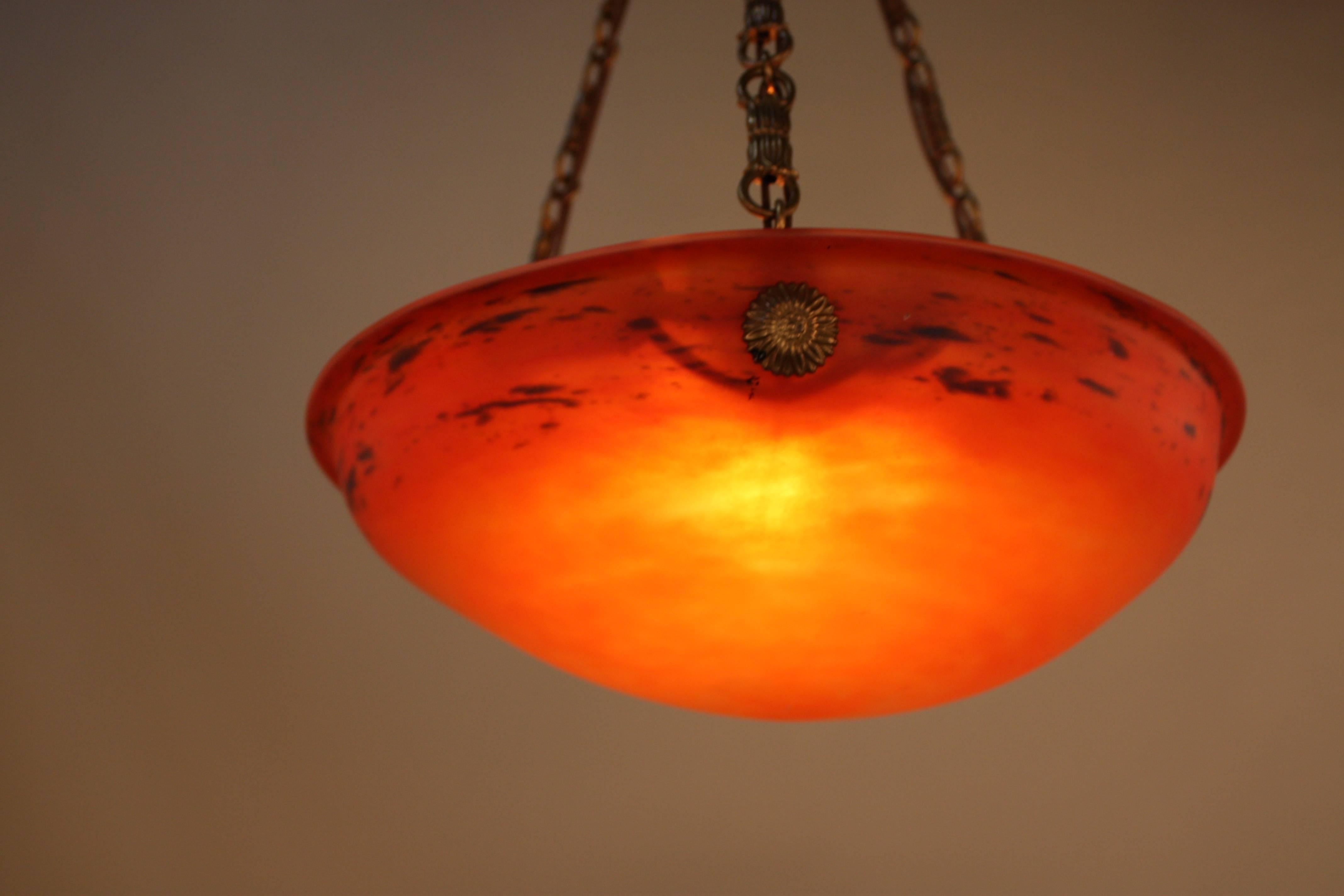 A French Art Deco glass nine-light ceiling pendant chandelier in Firey red/orange color. The shade is made by Schneider and suspended with bronze chain and canopy.