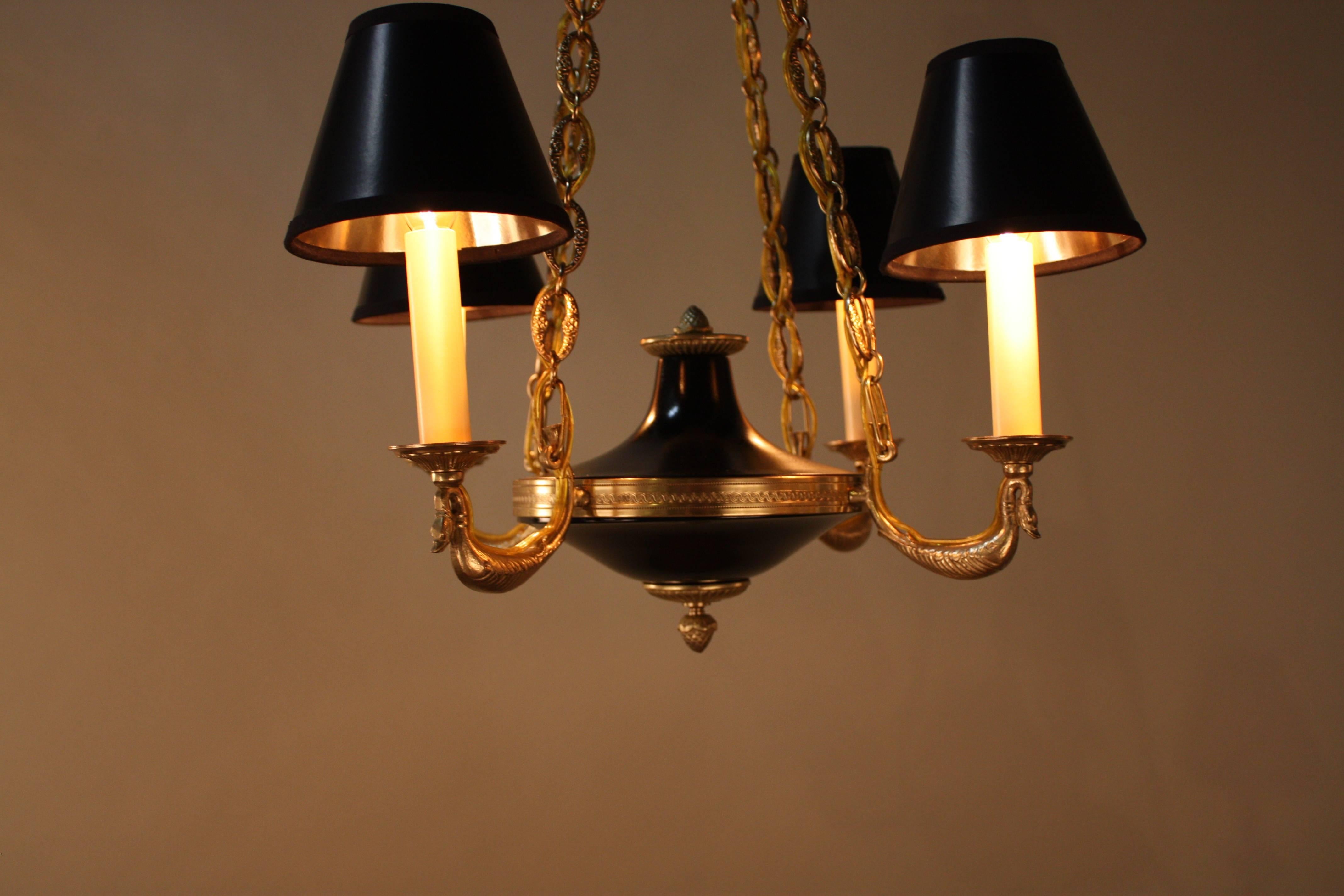 An elegant four-arm French bronze and black lacquer chandelier.
Measurement: Each arm extend 9.