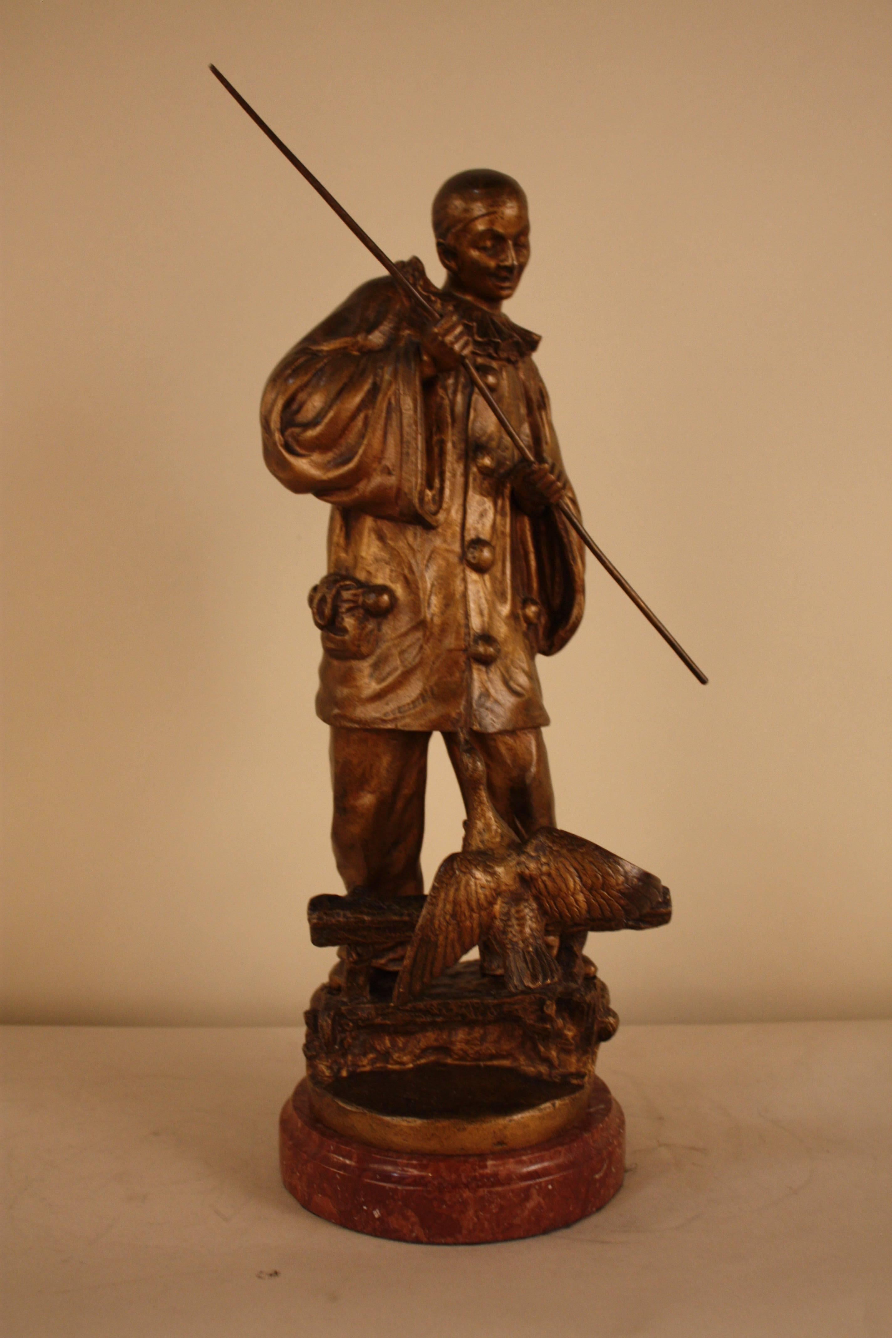 Bronze 1930s sculpture of harlequin with spear and a bird.
