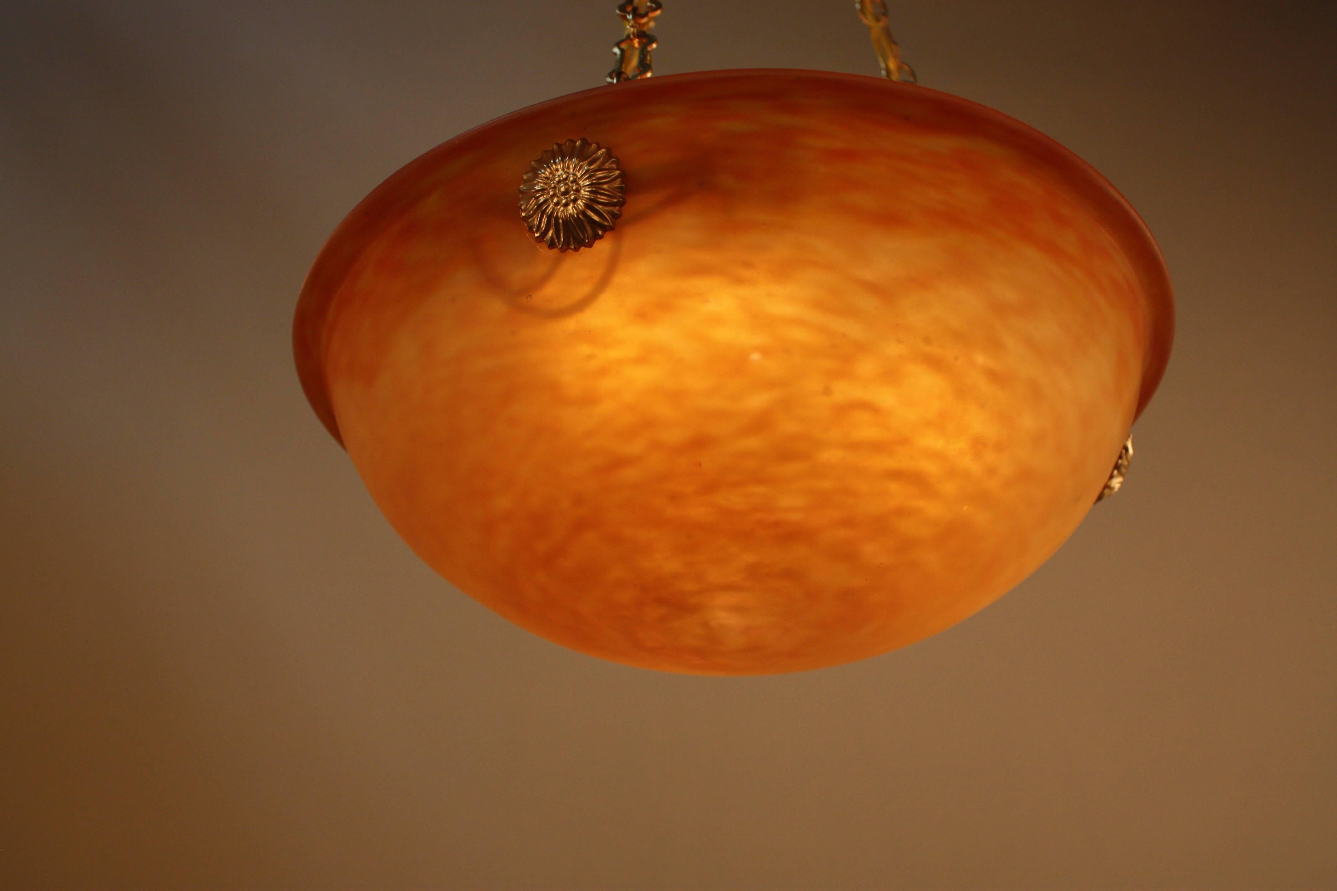 A fiery orange red color blown glass chandelier with golden bronze hardware.
Six-light, 60 watts max each.
