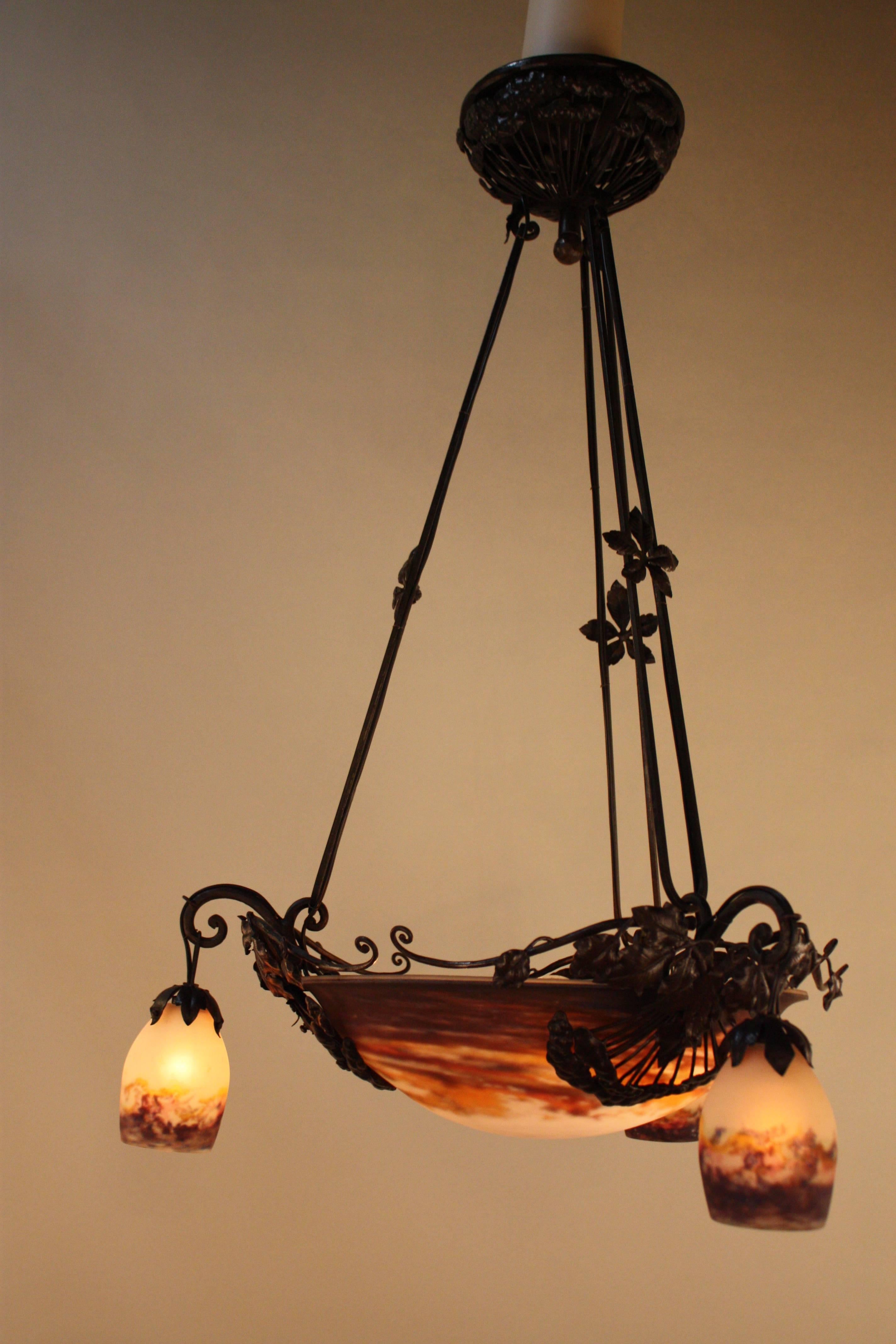 Stunning French Art Nouveau chandelier with handmade iron work and fabulous blown glass shades by Muller brothers in Luneville, France.
Total of twelve lights, 60 watt each.
