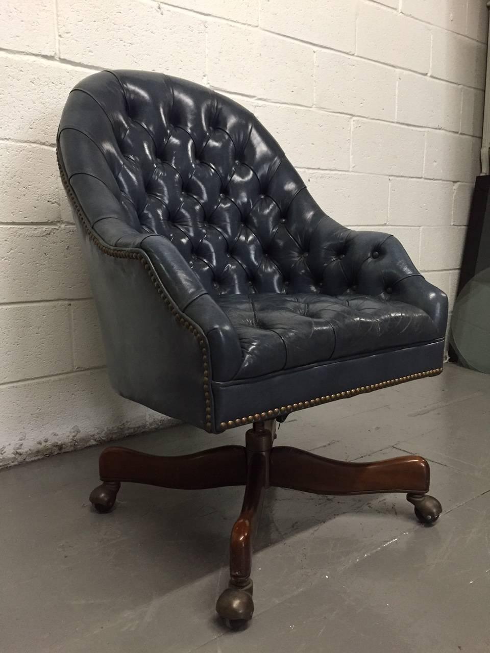 Schafer Bros tufted leather chair. Has a rolling wood base.