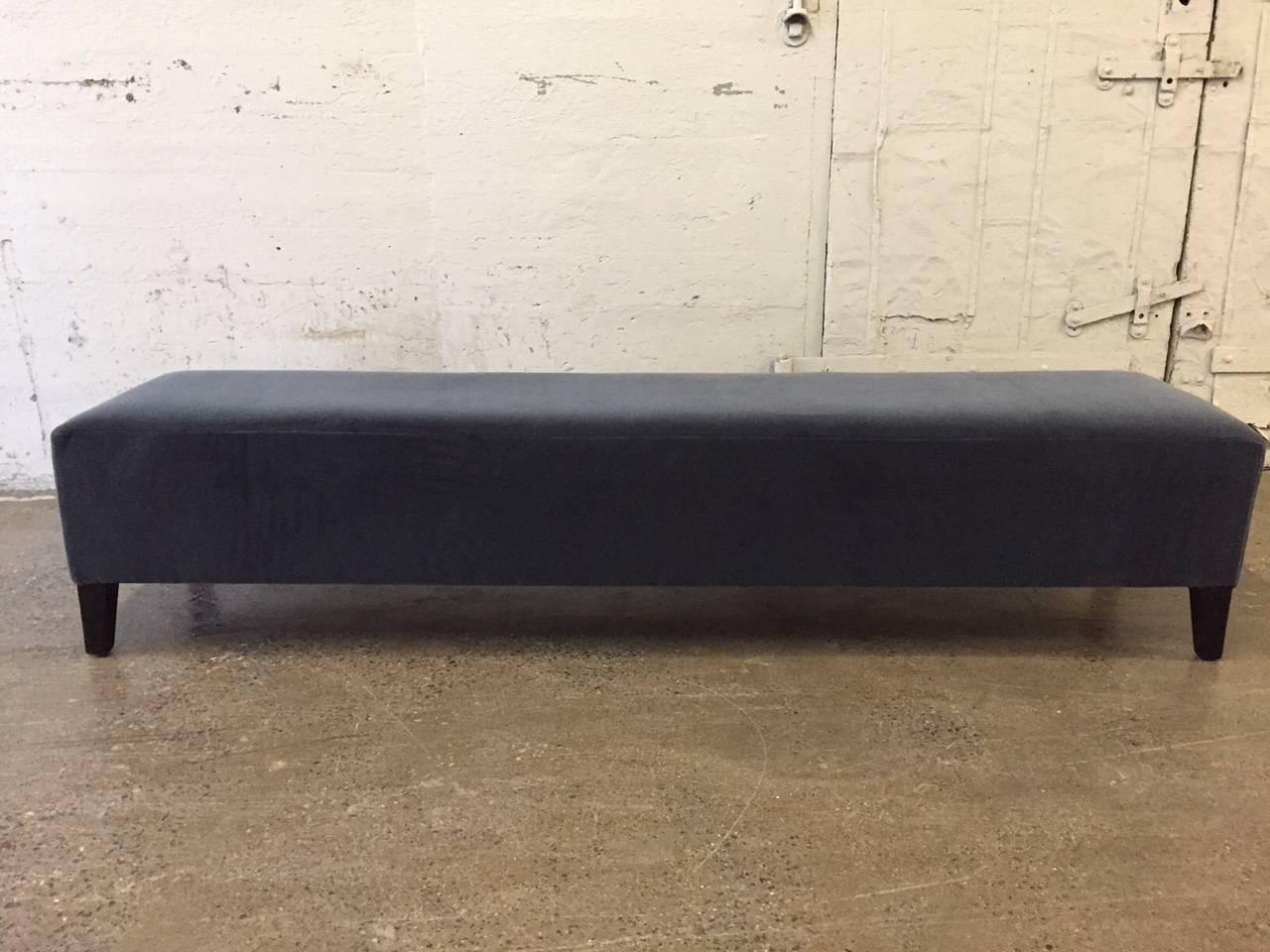 Long Art Deco upholstered bench.  Upholstered in velvet with black lacquered wood legs. 
