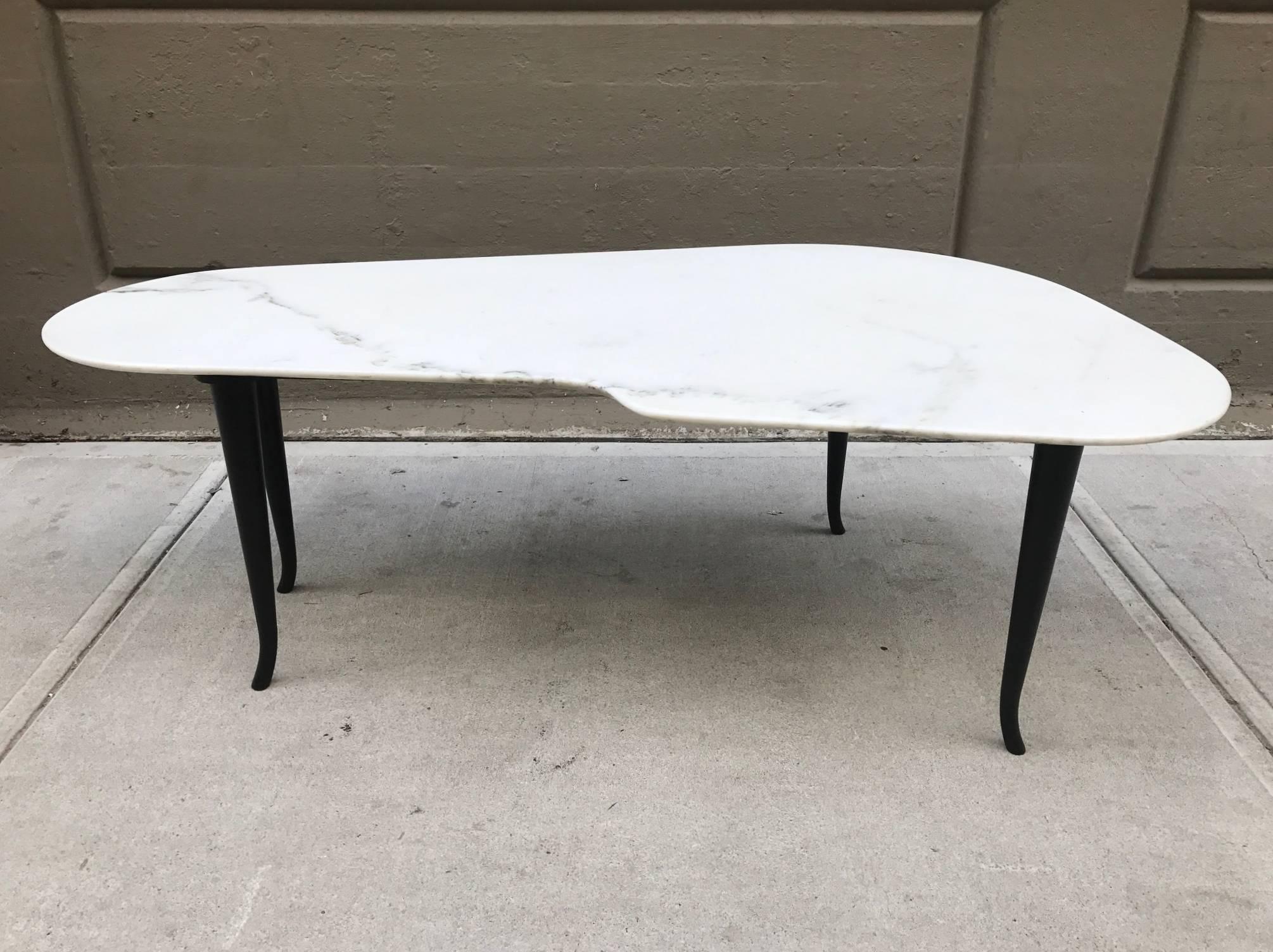 Marble-top coffee table in the style of T.H. Robsjohn-Gibbings. Has a sculptural Italian marble top with a black lacquered base.