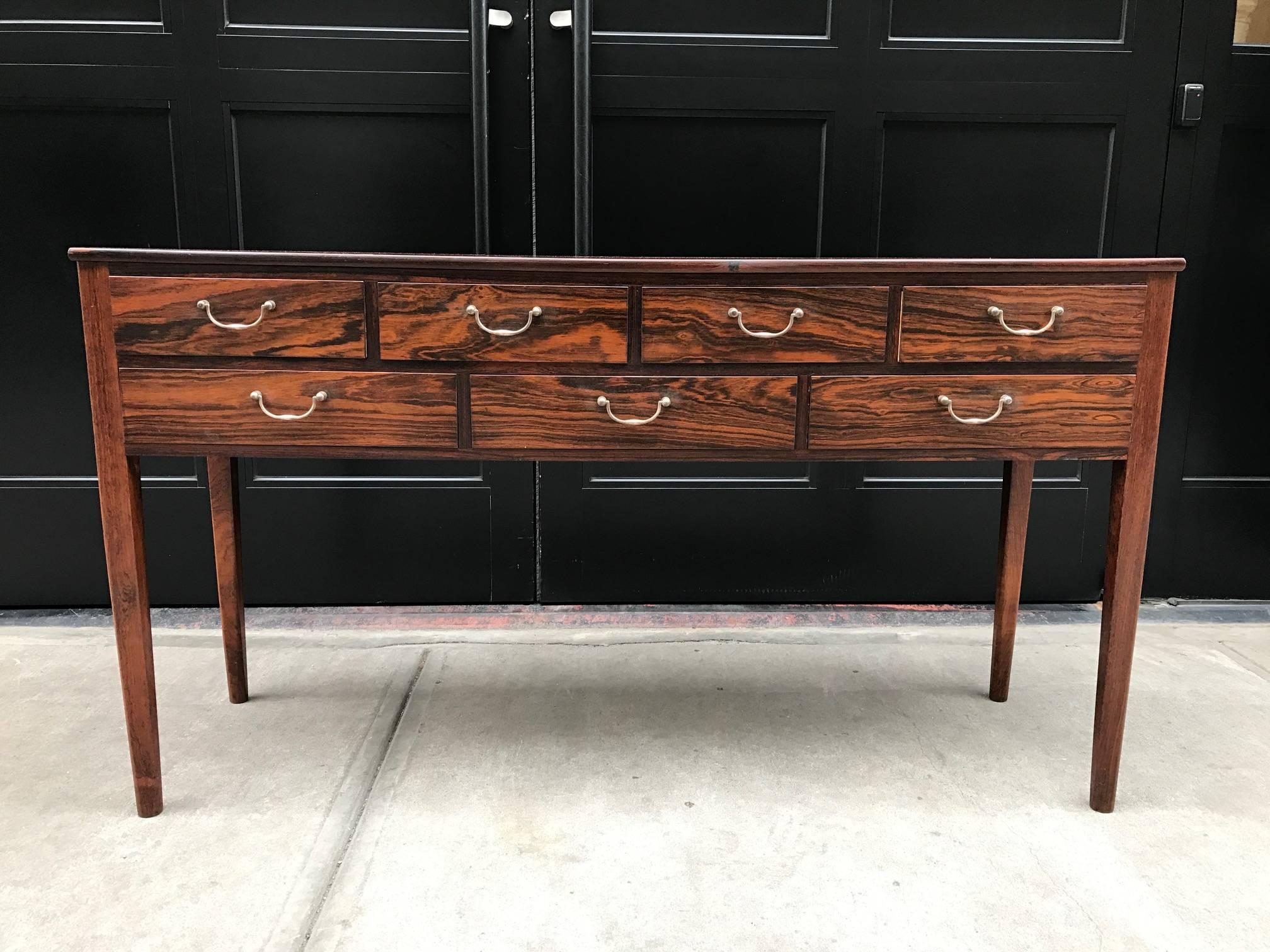 Early Ole Wanscher rosewood server table for A. J. Iversen.  Has a finished rosewood back, seven pull out drawers and original brass handles.  Retains Illums Bolighus label.  
