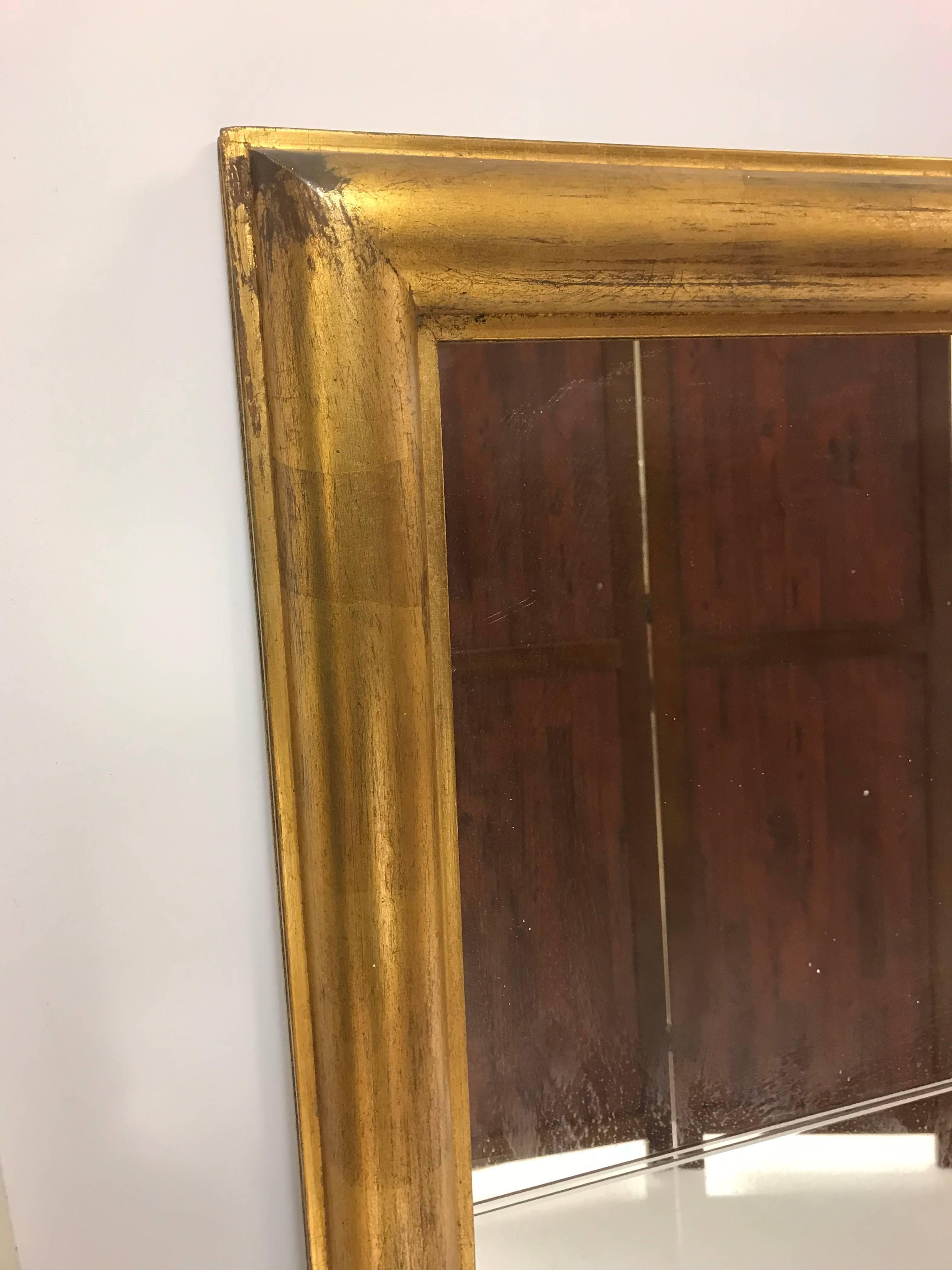 Large Tommi Parzinger mirror. This mirror is divided into nine sections with deep etching. Tommi Parzinger originals. Giltwood frame with brass ring and nice patina.