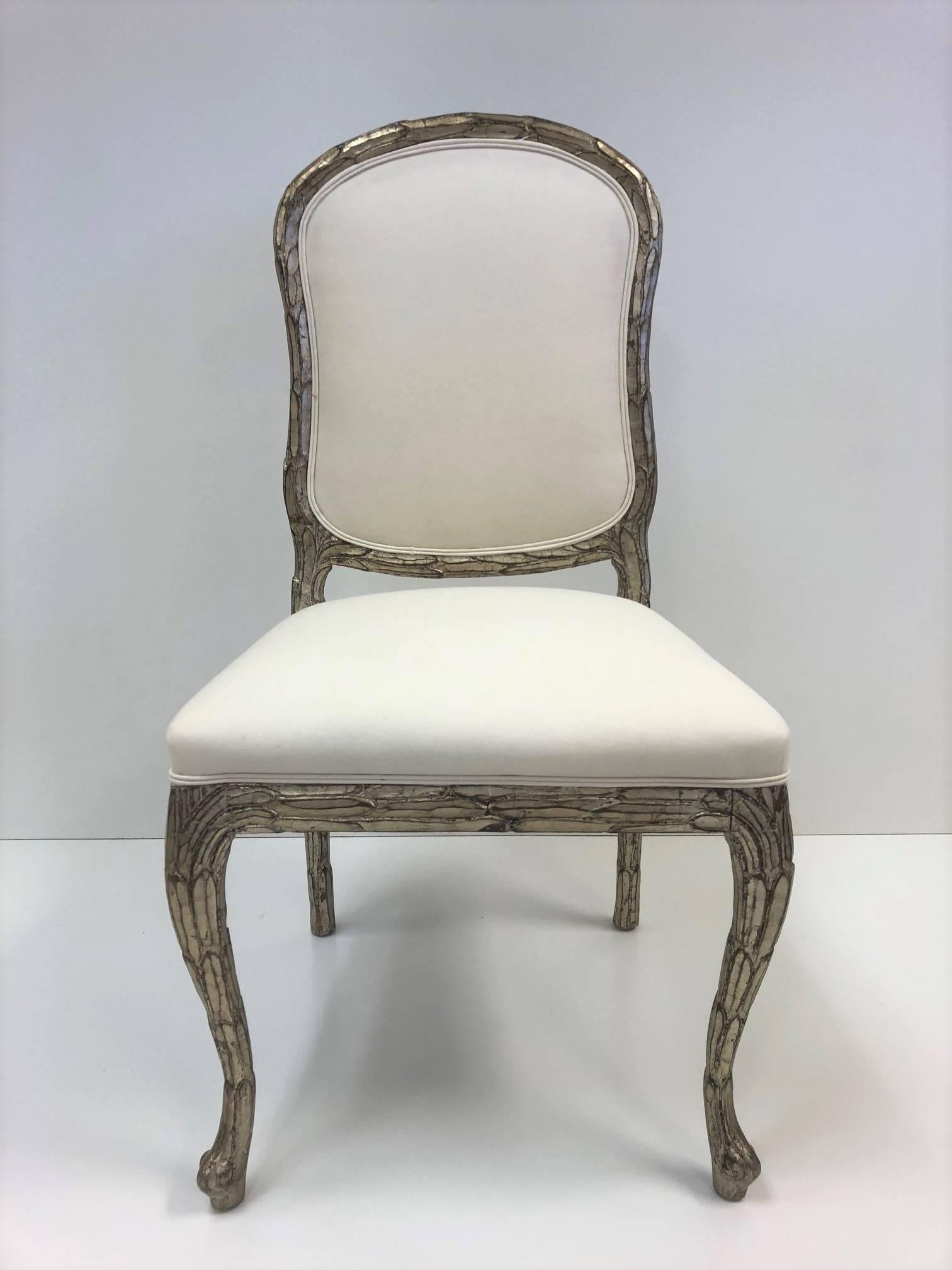 Set of 10 Louis XIV Style Dining Chairs.  The chairs are upholstered in muslin with silver leaf carved wood frame. 
Arms: 40.25H x 23.5W x 224D.  Arm height: 27.5H.  Seat height: 19H
Without Arms:  38.25H x 19.5W x 20.5D. 