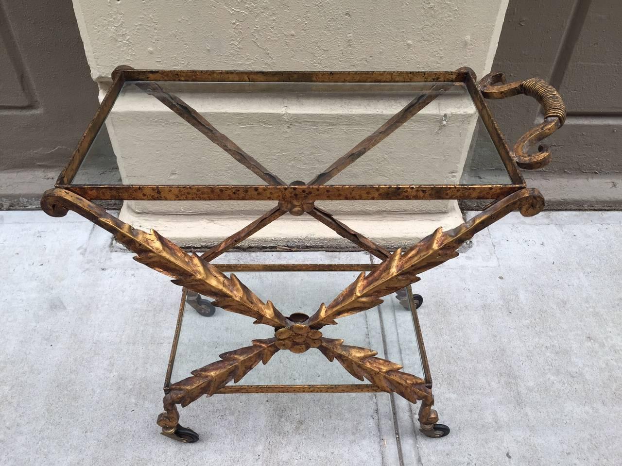 Two-tier, glass tops, French iron gilt bar or serving cart.

