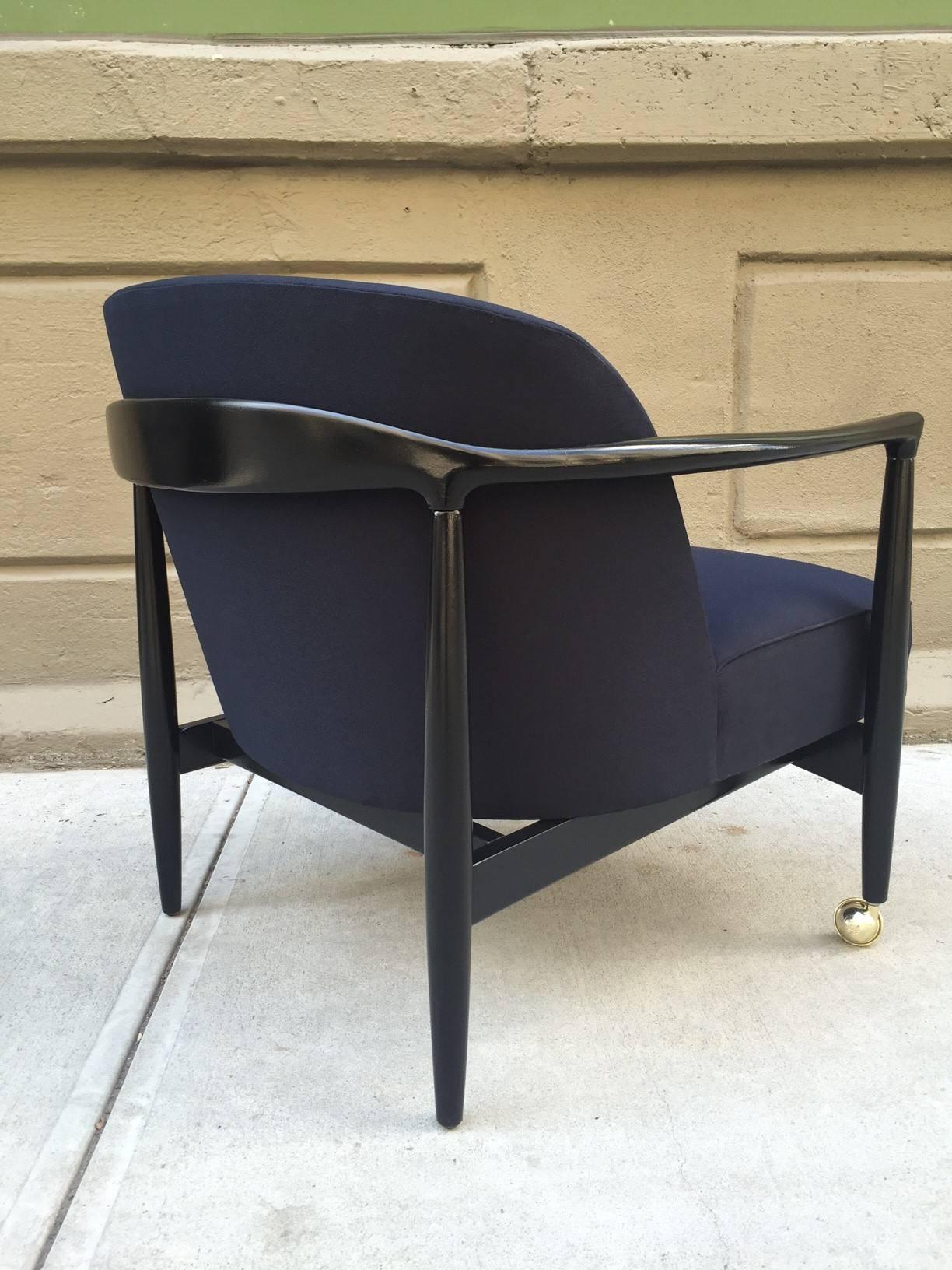 Pair of sculptural Ib Kofod-Larsen lounge chairs. Casters to the front legs. Black lacquered sculptural frame. Newly upholstered. The upholstery is a lighter black than the frame. 