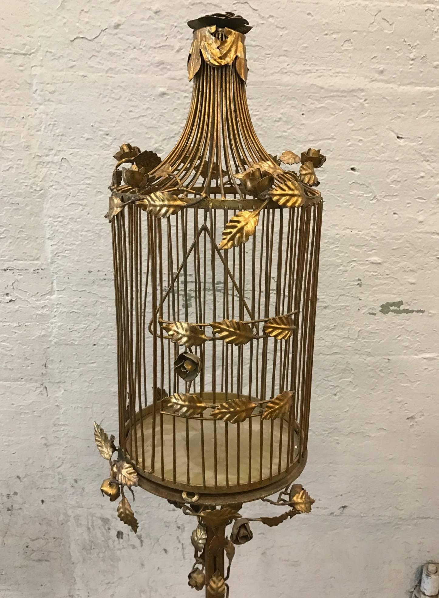 Vintage iron gilt bird cage with marble base. Cage has a decorative floral pattern and a slide out tray. 