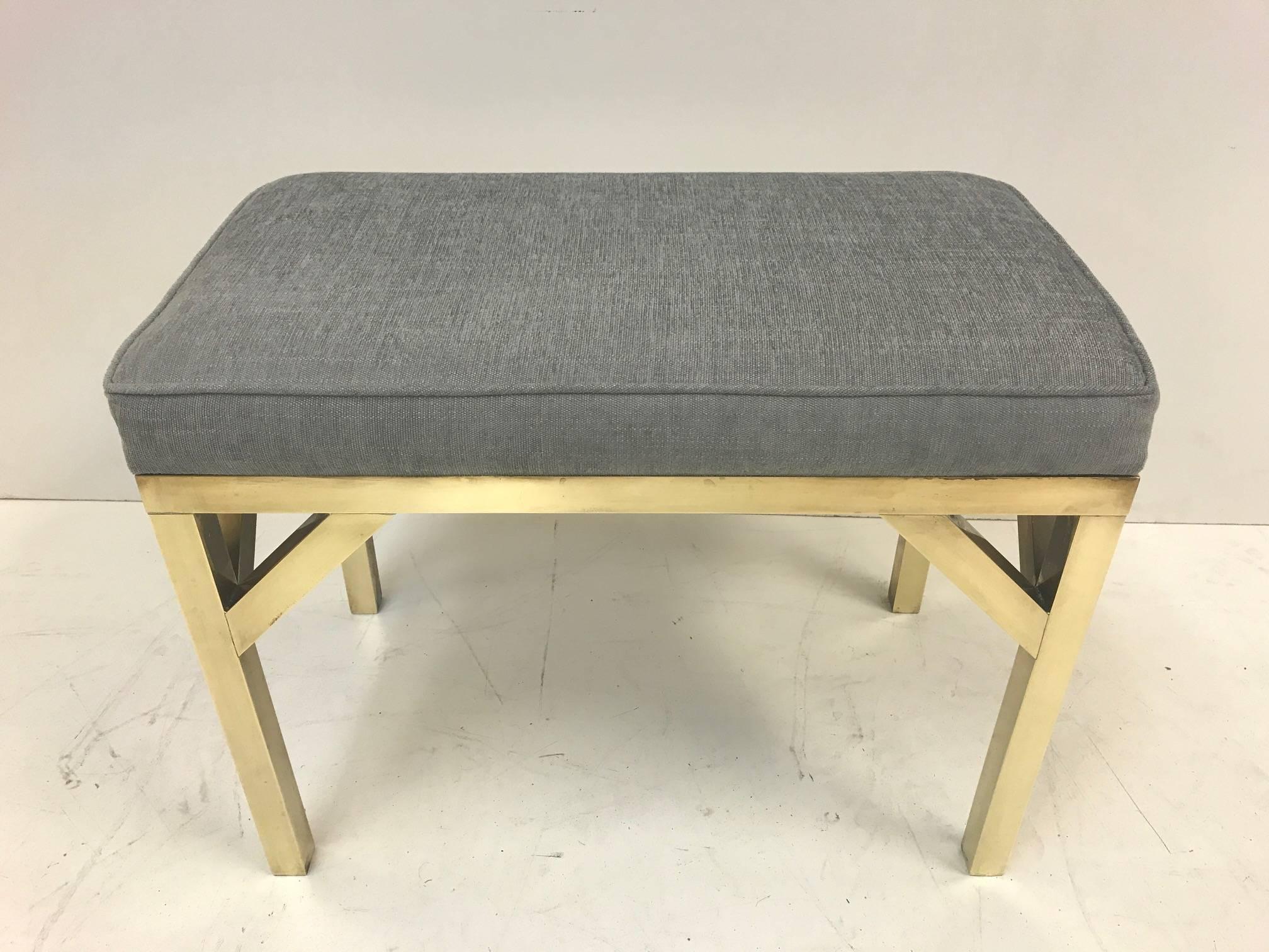 Pair of brass upholstered benches. Newly upholstered in a gray linen-blend fabric. 