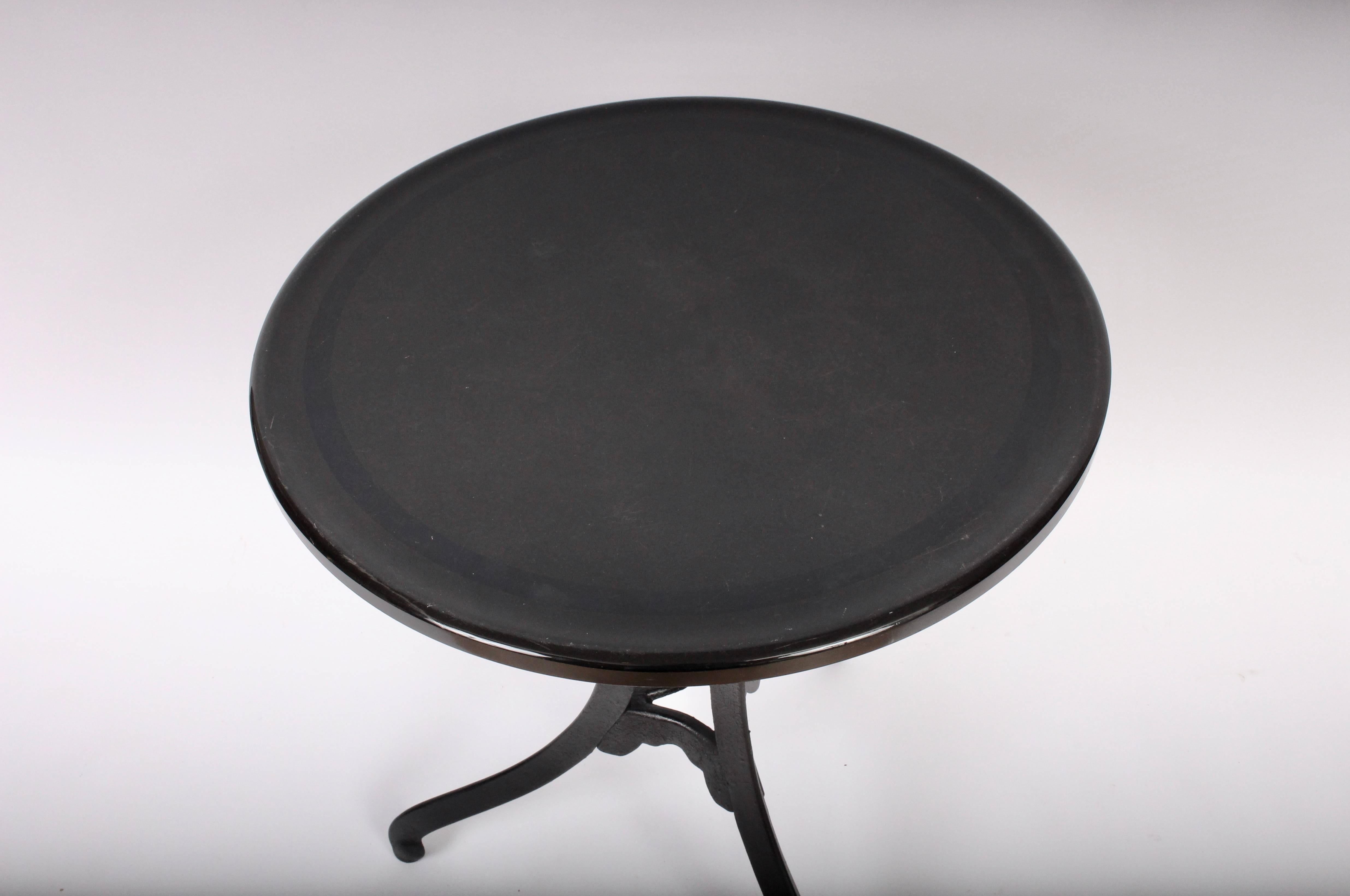 Elegant Edwardian Cast Iron and Black Glass Cafe Table, Front Hall Table, Occasional Table. Featuring an Black Cast Iron tripod base with original vintage round, rounded edge one inch Black Vitrolite glass surface. Minor surface wear to glass. 24W