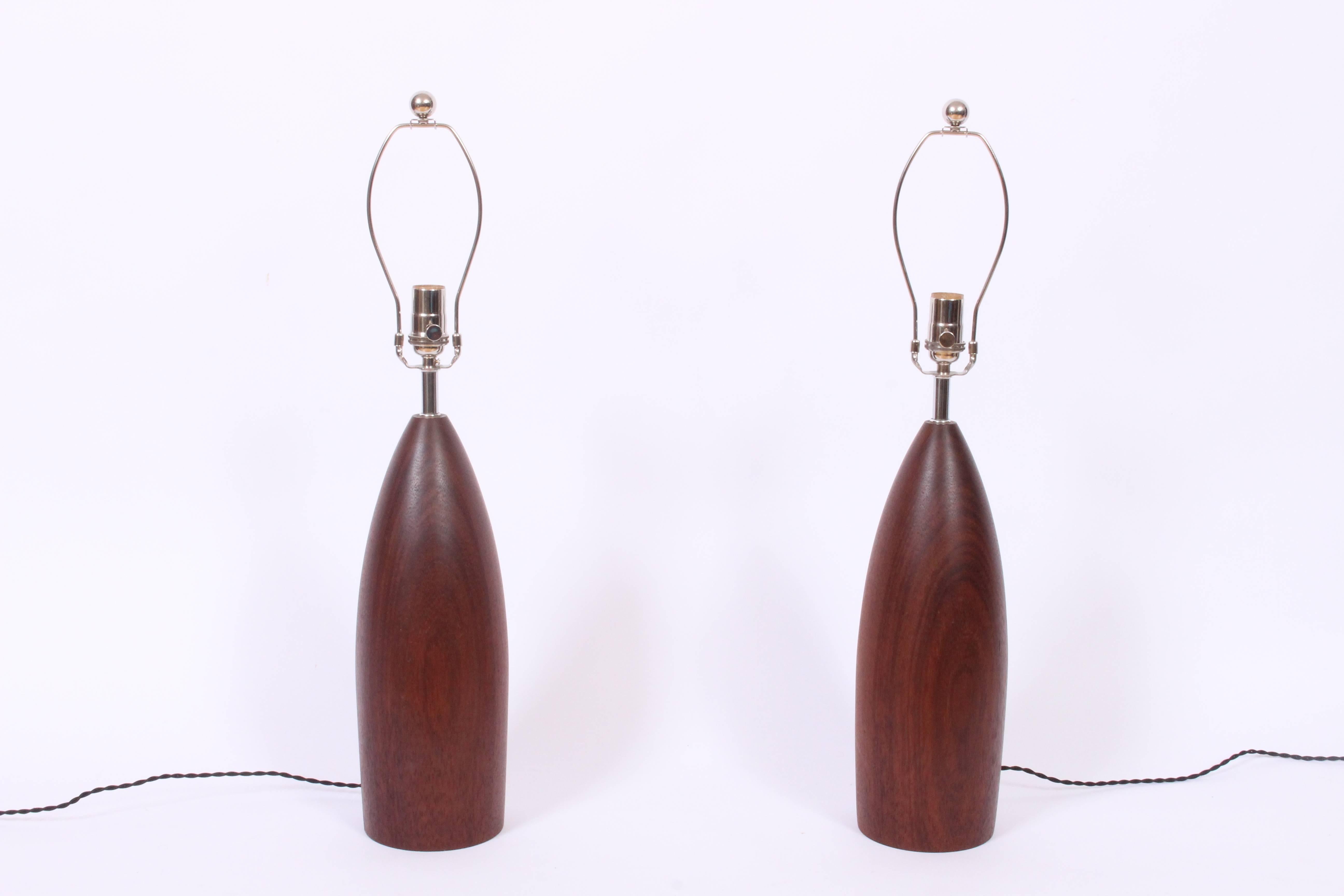 Large pair of Scandinavian Modern deep brown tapered solid Teak Table Lamps. Beautifully turned smooth bullet form. 21 H to top of socket. Shades shown for display only (9.5 H x 12 D top x 13 D bottom). Rewired with new nickel-plated hardware and