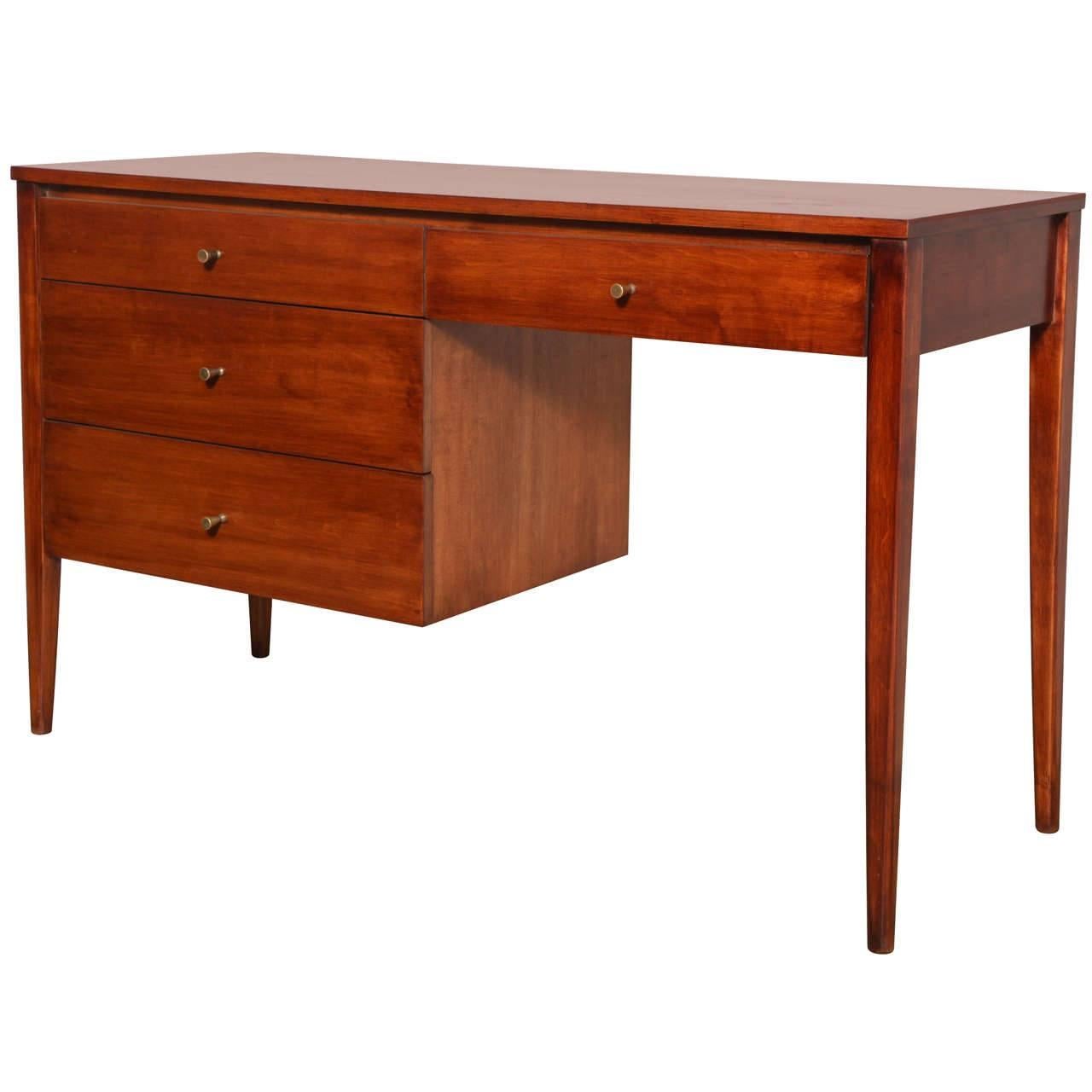 American Mid-Century Modern Paul McCobb Planner Group for Winchendon Desk. Featuring a solid beautifully grained wooden desk with four deep drawers, warm finish, rectangular tapered legs and original Brass hour glass pulls. Newly refinished.