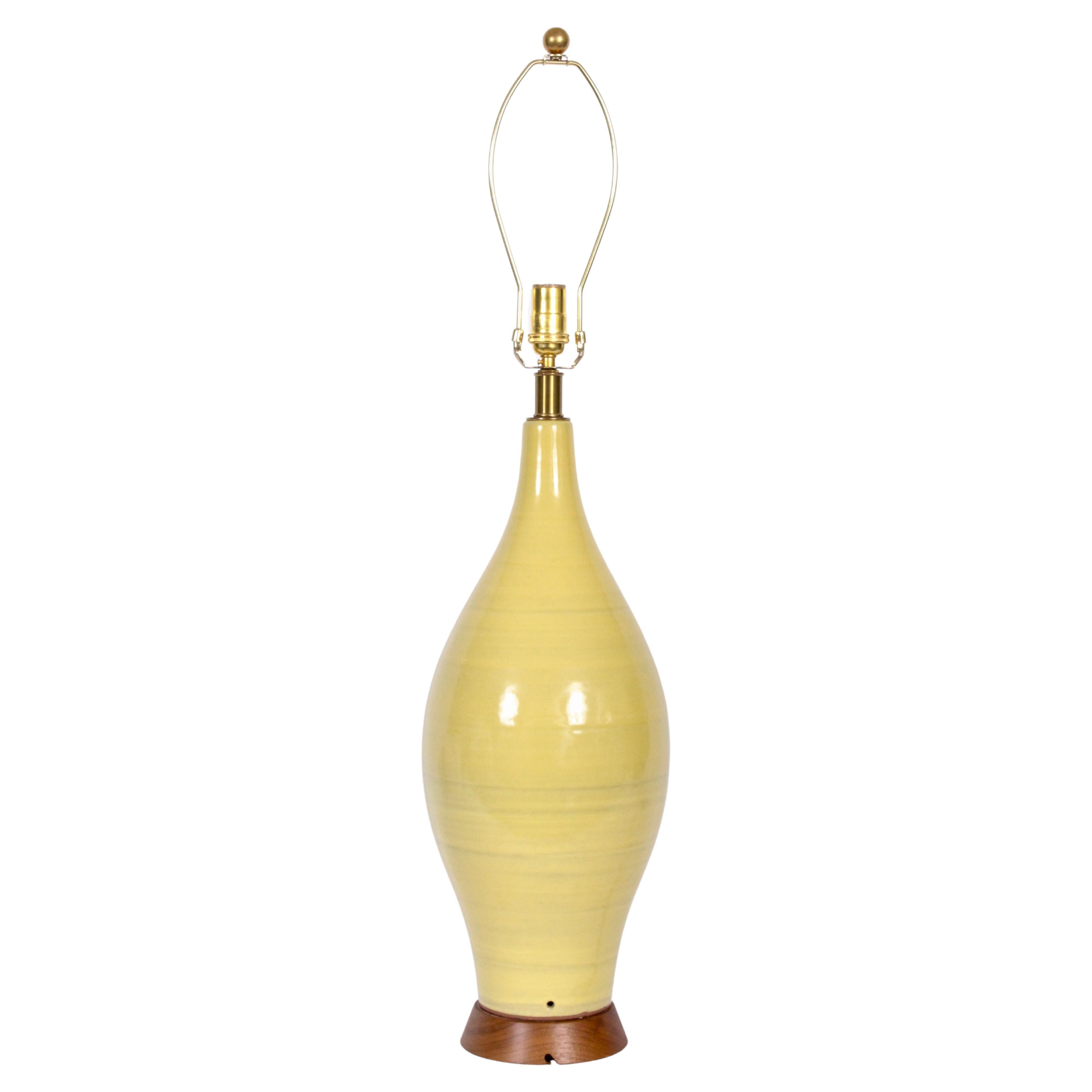 Substantial 3'H Design-Technics handcrafted Vibrant Yellow Pottery Lamp, 1960s.  Featuring the classic hand sculpted bottle form with vertical banding and reflective glossy glaze on solid flared walnut base. 28 H to top of socket. Ceramic 22.5 H.