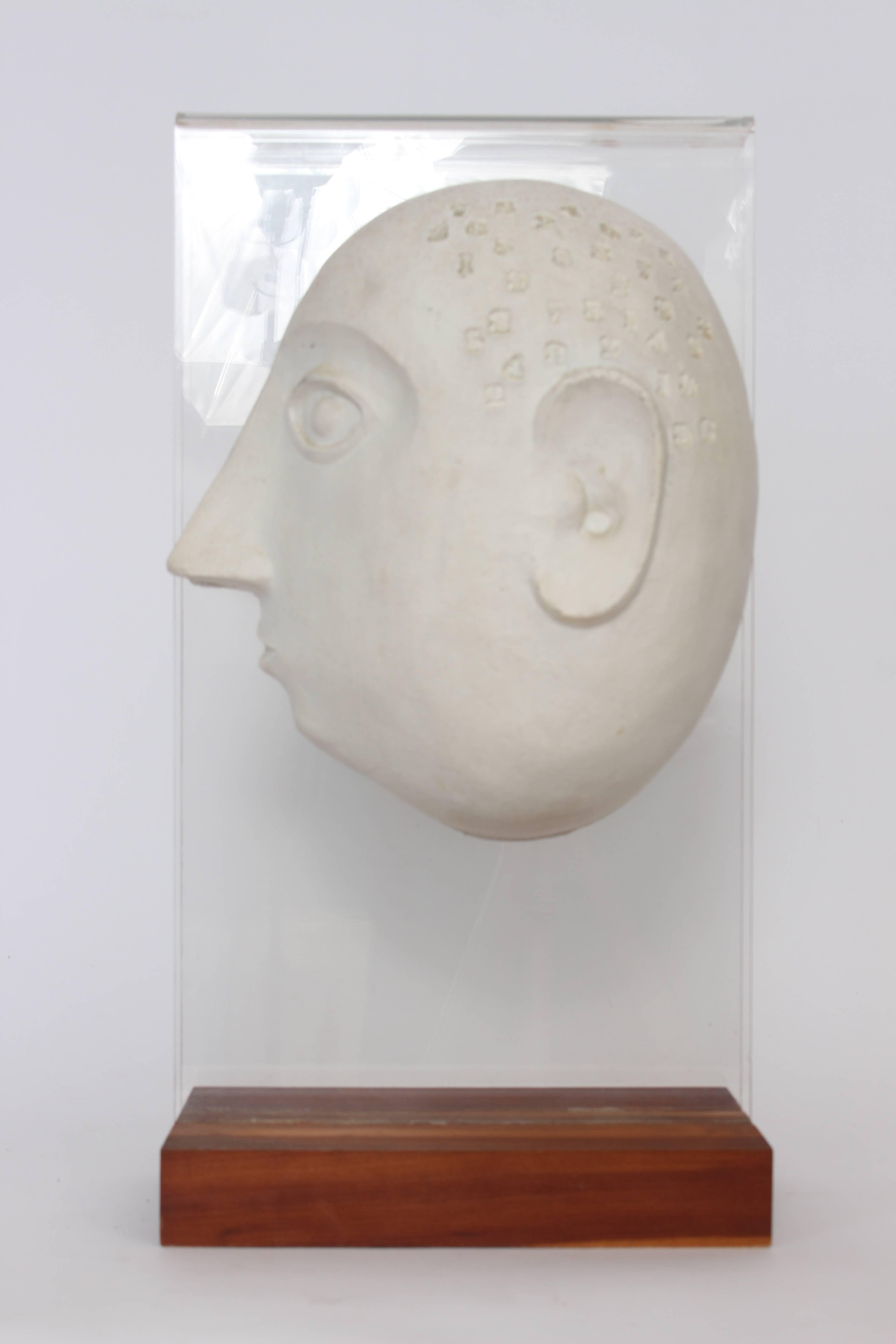 Psychological portrait of a man in Ceramic, Lucite and Wood, 1949, by Bennington Potters Founder, David Gil.  The split male profile Caricature in Off-White Ceramic features stamped numbers with Lucite support and rectangular wooden base. (Base 10 x