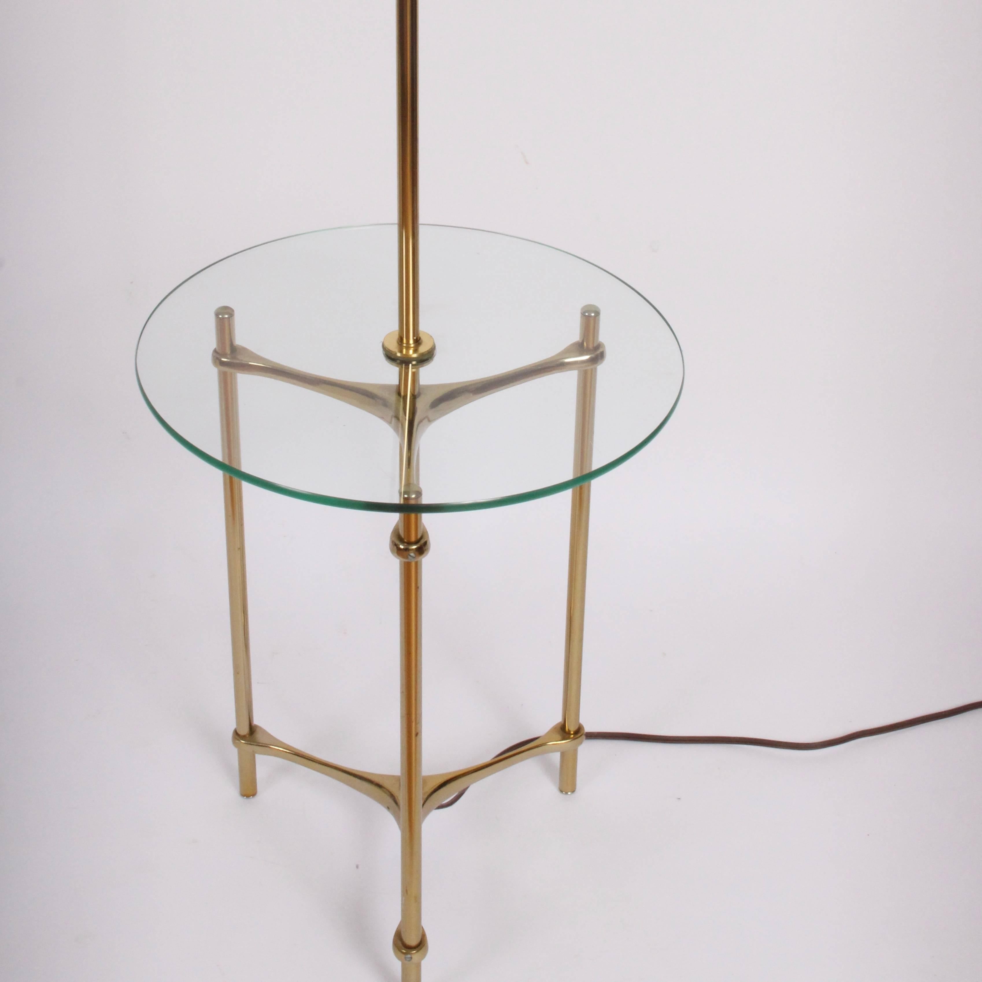 Classic 1970s Laurel Lamp Mfg. Co. Lamp Table in Brass and Glass. The Duo Reading Lamp Side Table features a tubular Brass stem, 
three legged tripod base and round 16 D Glass table surface. Sturdy. Versatile. Lampshade (12 H x bottom 16 D x top 10
