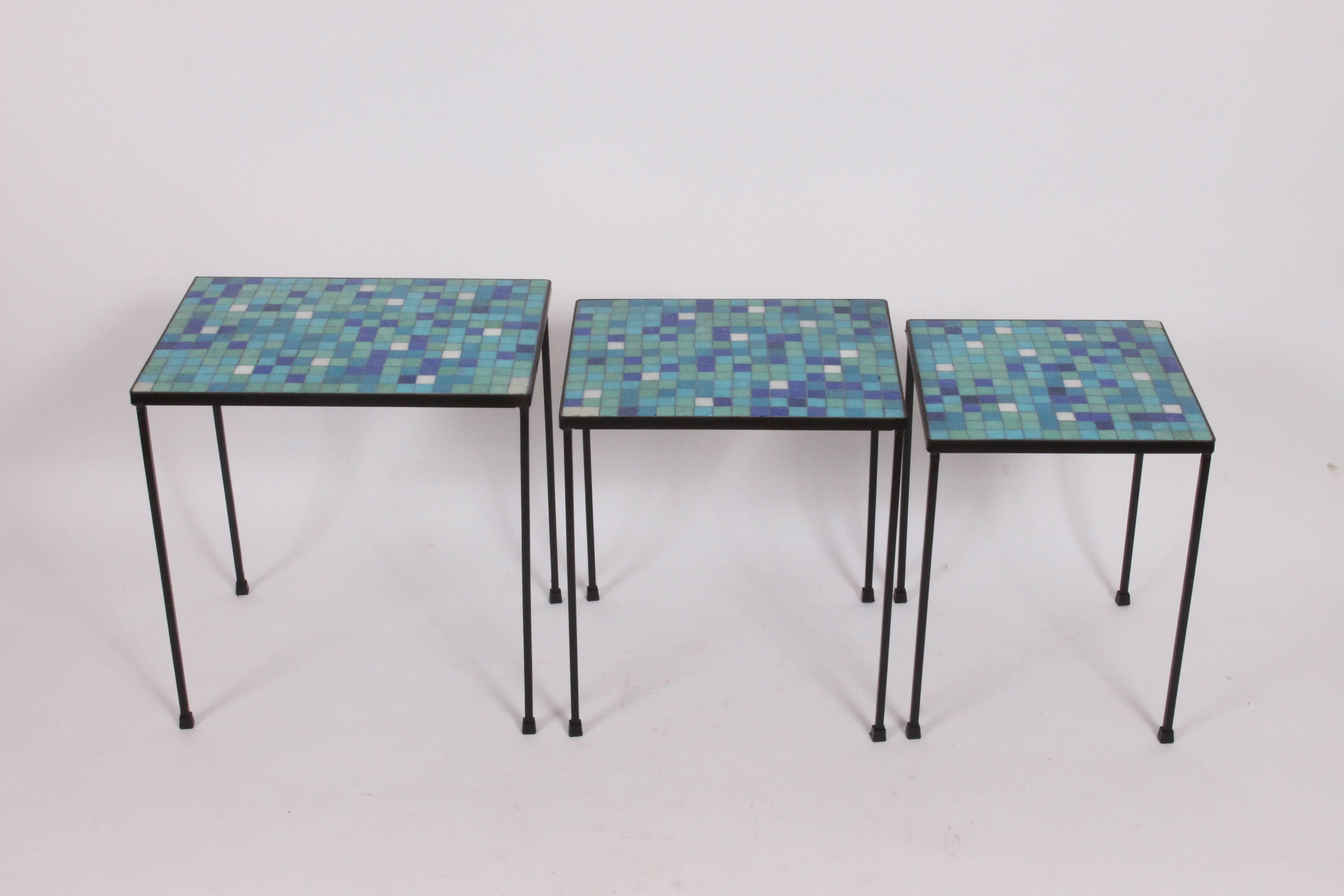 American midcentury black iron and terrazzo tile indoor outdoor tables. Featuring a rectangular wrought iron framework, blue and green hued terrazzo tiles with white accent tiles. Medium table (17 H x 12.5 D x 15 W) small table (16 H x 12.5 D x 12.5