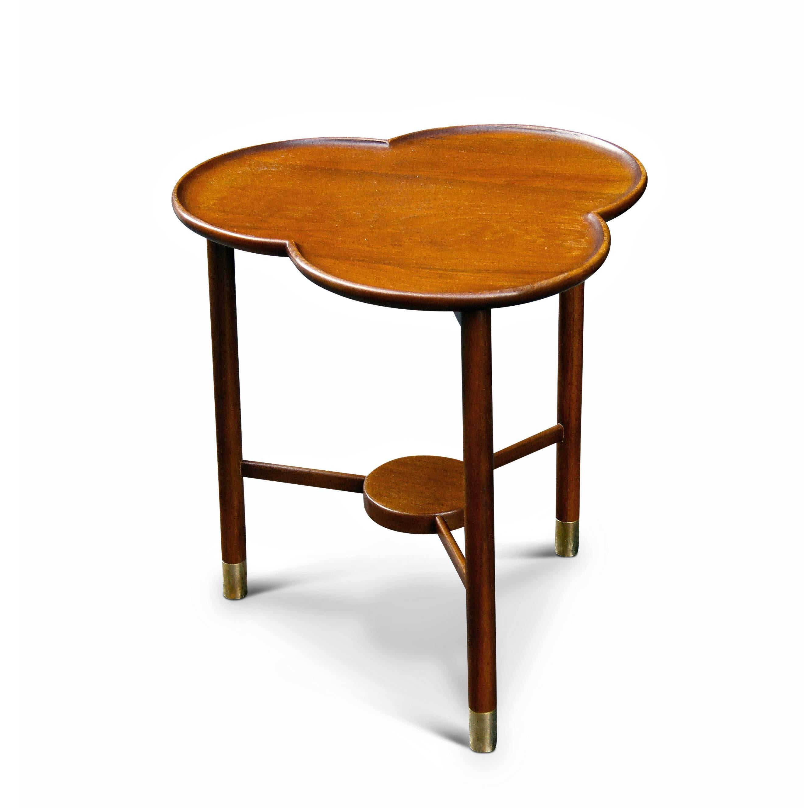 Occasional table having sculptural trefoil (three lobed) shape top with carved curving lip, supported on a three leg base with stretchers, exhibiting a fine degree of craftsmanship, executed in oak with brass sabots, Denmark, mid-20th century.

 